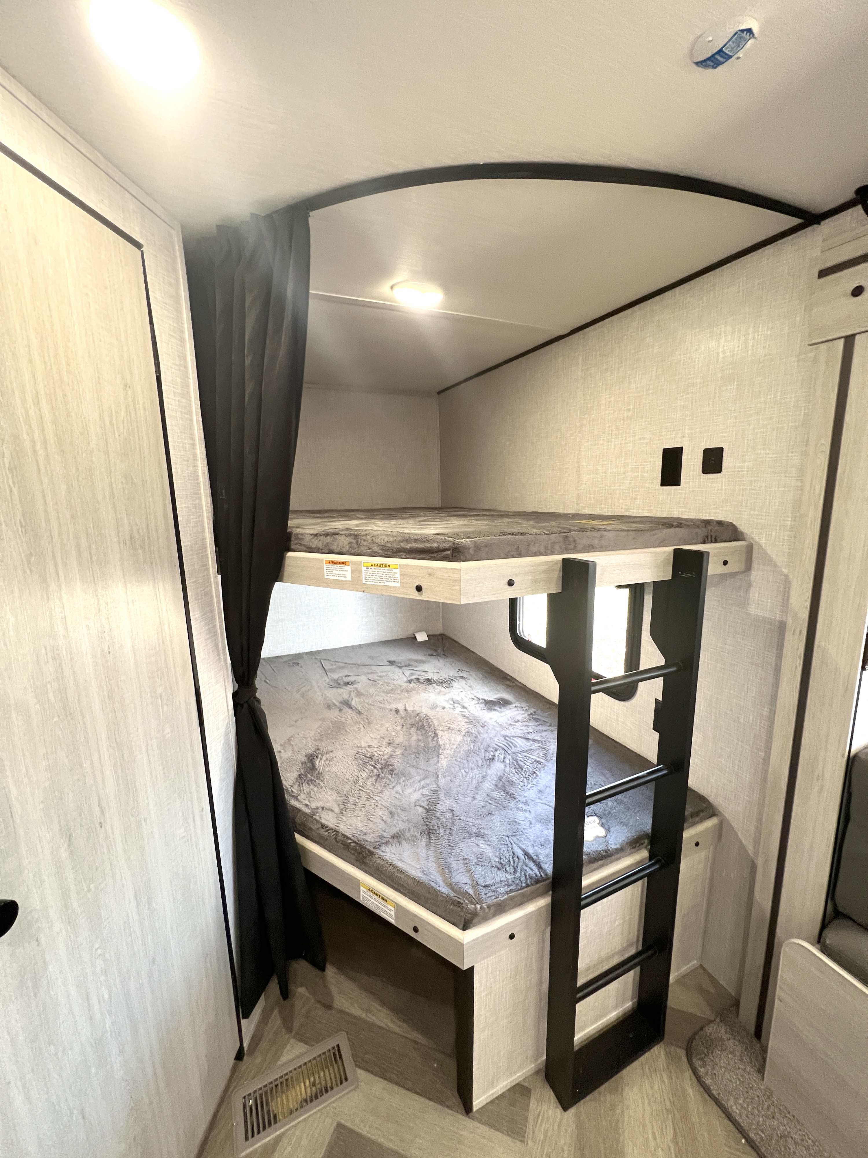 This RV rental features a compact interior with cozy bunk beds and a ladder, offering a comfortable sleeping area for travelers.. Crossroads Zinger 2023