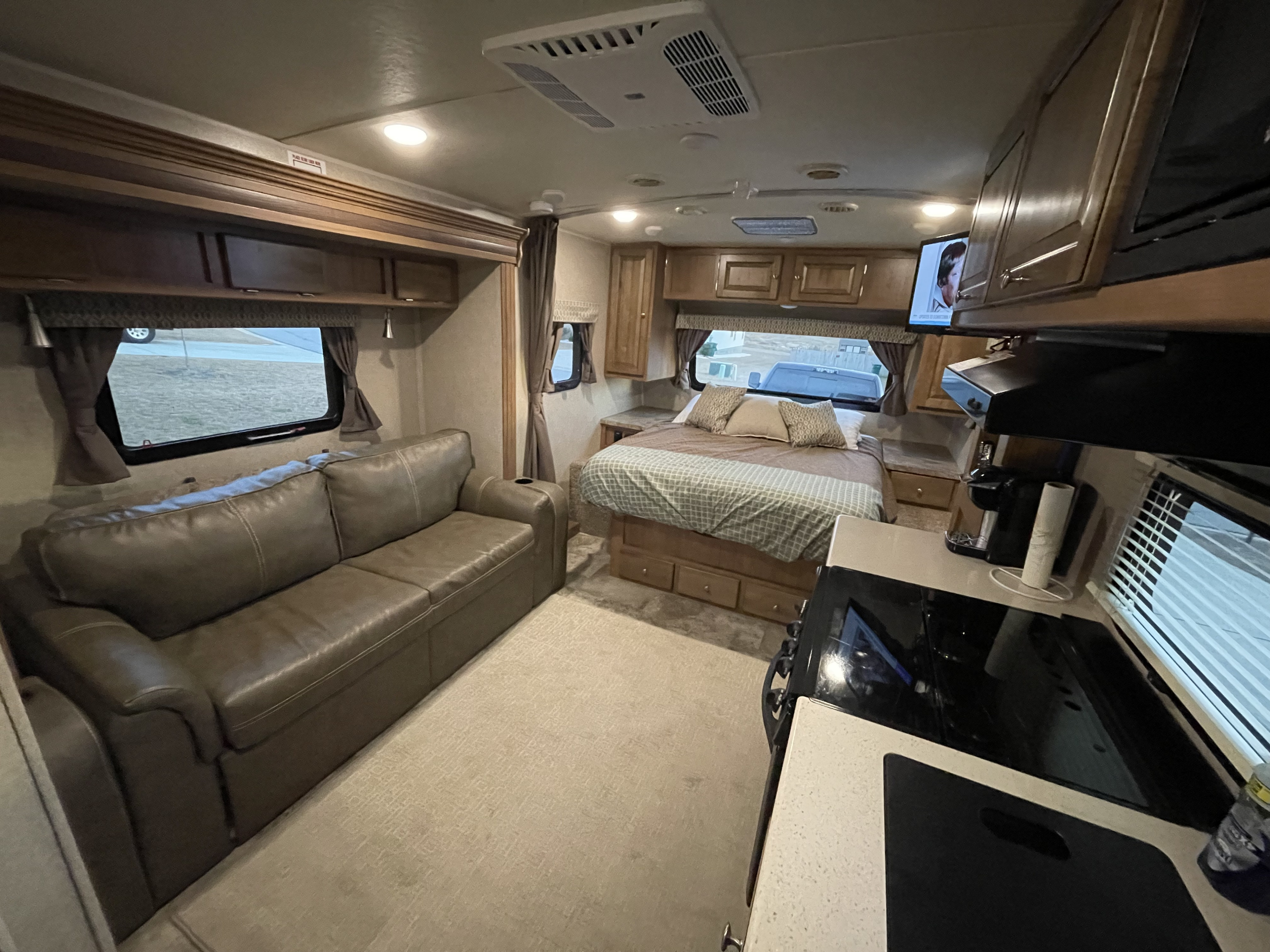 Inside a modern rv rental, featuring a comfortable sofa, bedroom, and functional kitchen area.. Forest River Flagstaff Micro Lite 2017