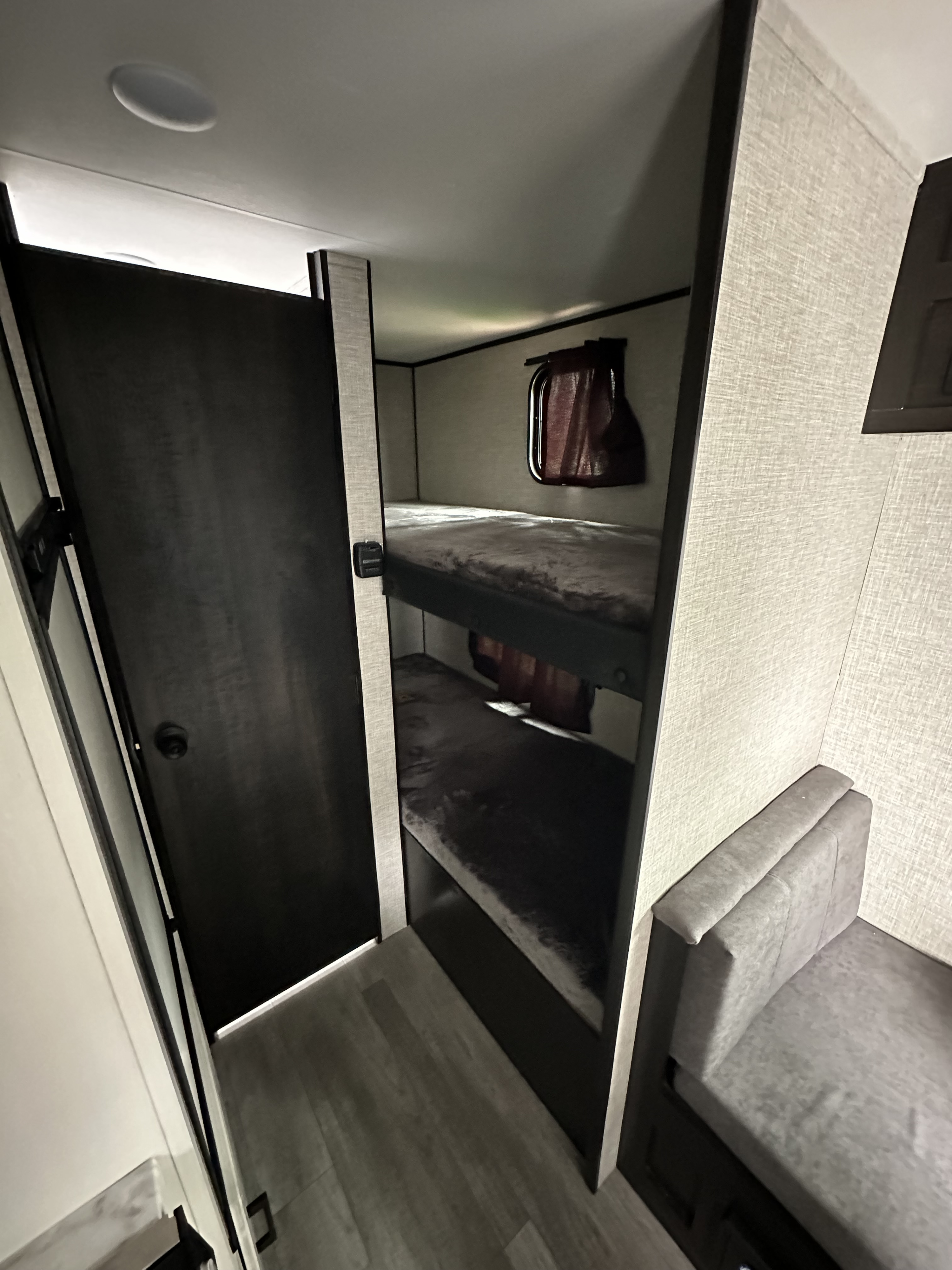 Modern RV rental interior with cozy bunk beds and a small dinette, ideal for compact living and family adventures.. Jayco Jay Flight SLX 2023