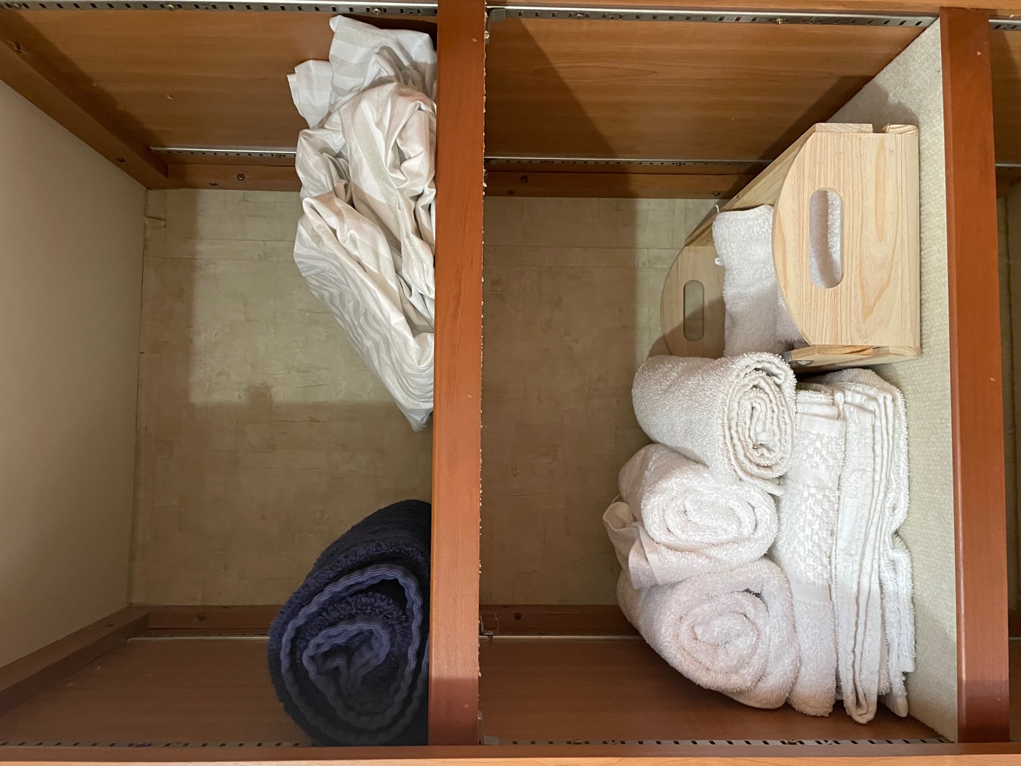 RV rental linen storage: neat shelves with rolled white & blue towels, folded linens, and a wood caddy.. Allegro Allegro Motorhome 2008