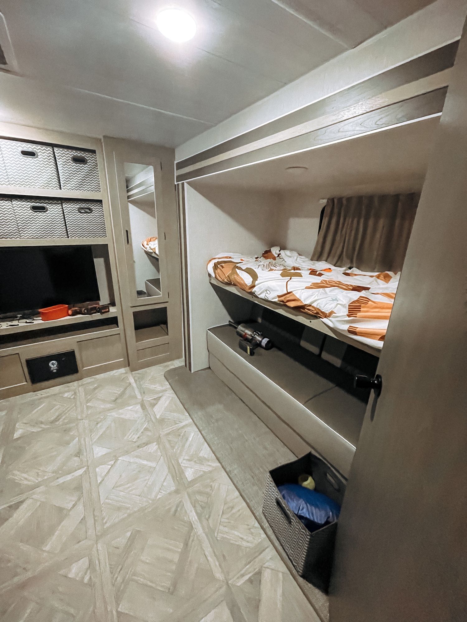 Cozy RV rental interior with bunk beds, TV, and smart storage, offering compact and comfortable living space.. Forest River Wildwood 2023