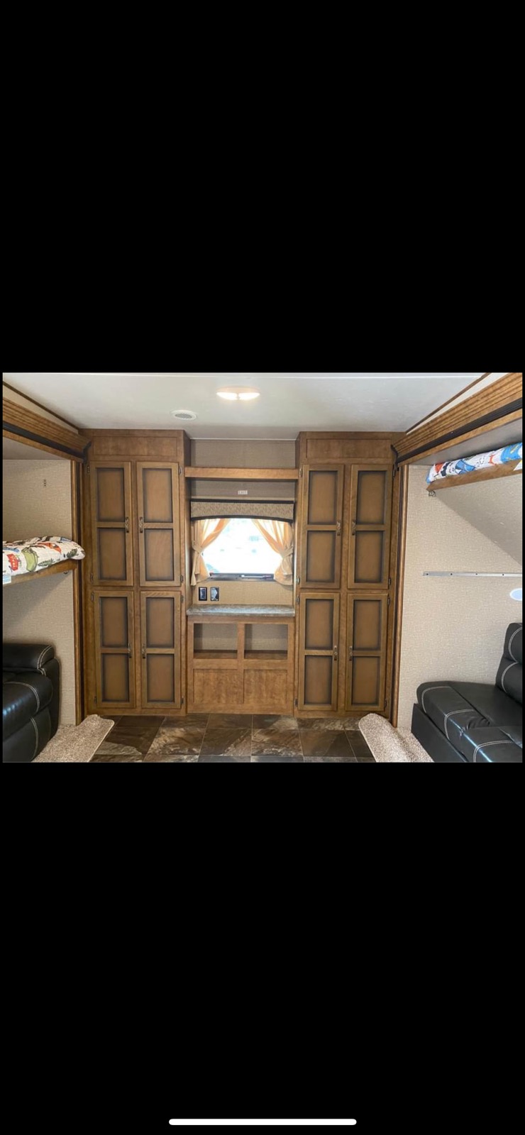 RV rental interior featuring extensive wooden cabinetry, bunk beds, and cozy seating.. Crossroads RV Volante 2018