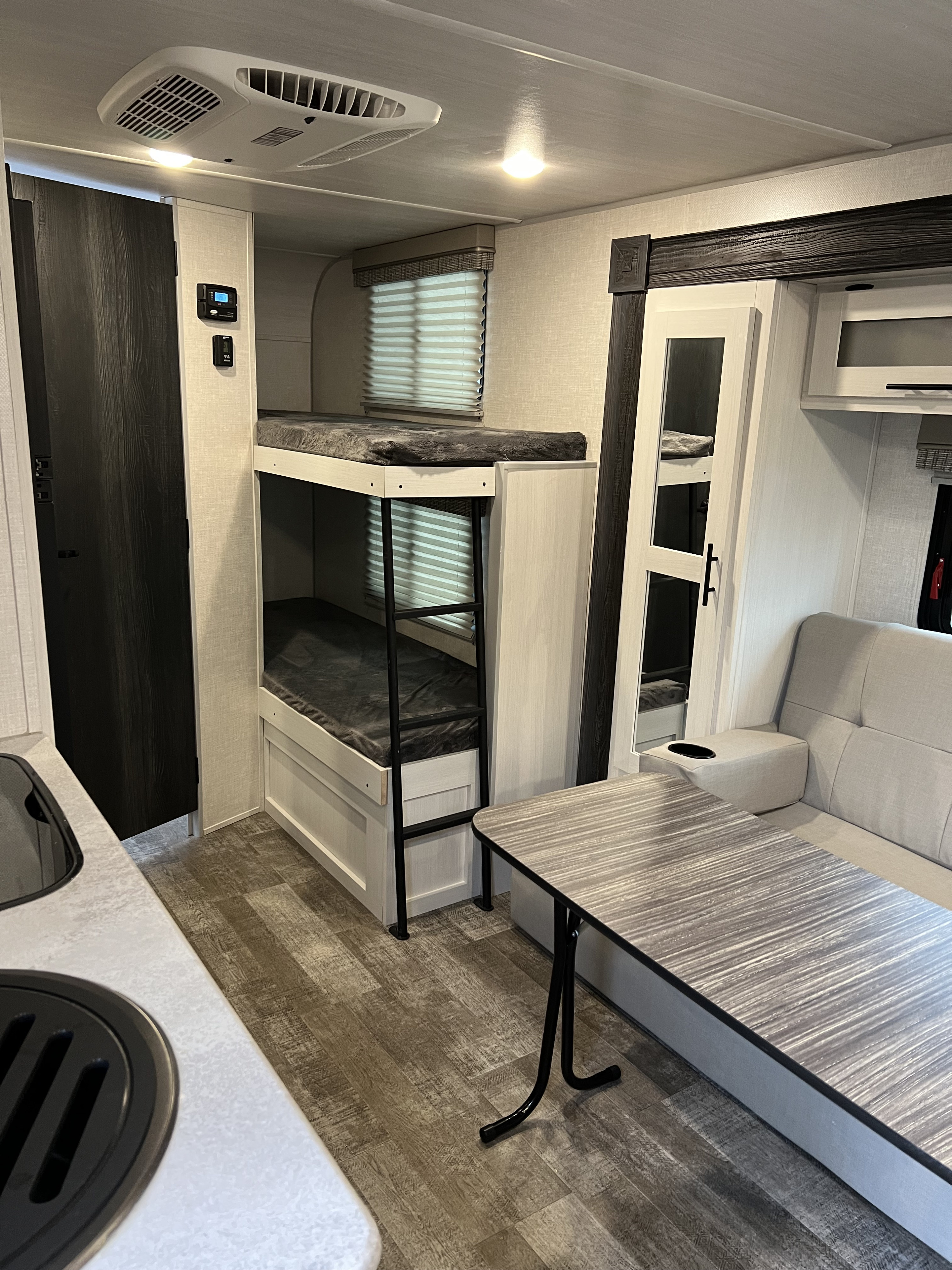 Spacious RV rental interior with bunk beds, a dinette, and kitchen counter. Ideal for family road trips.. Forrest River R-Pod 193 2022