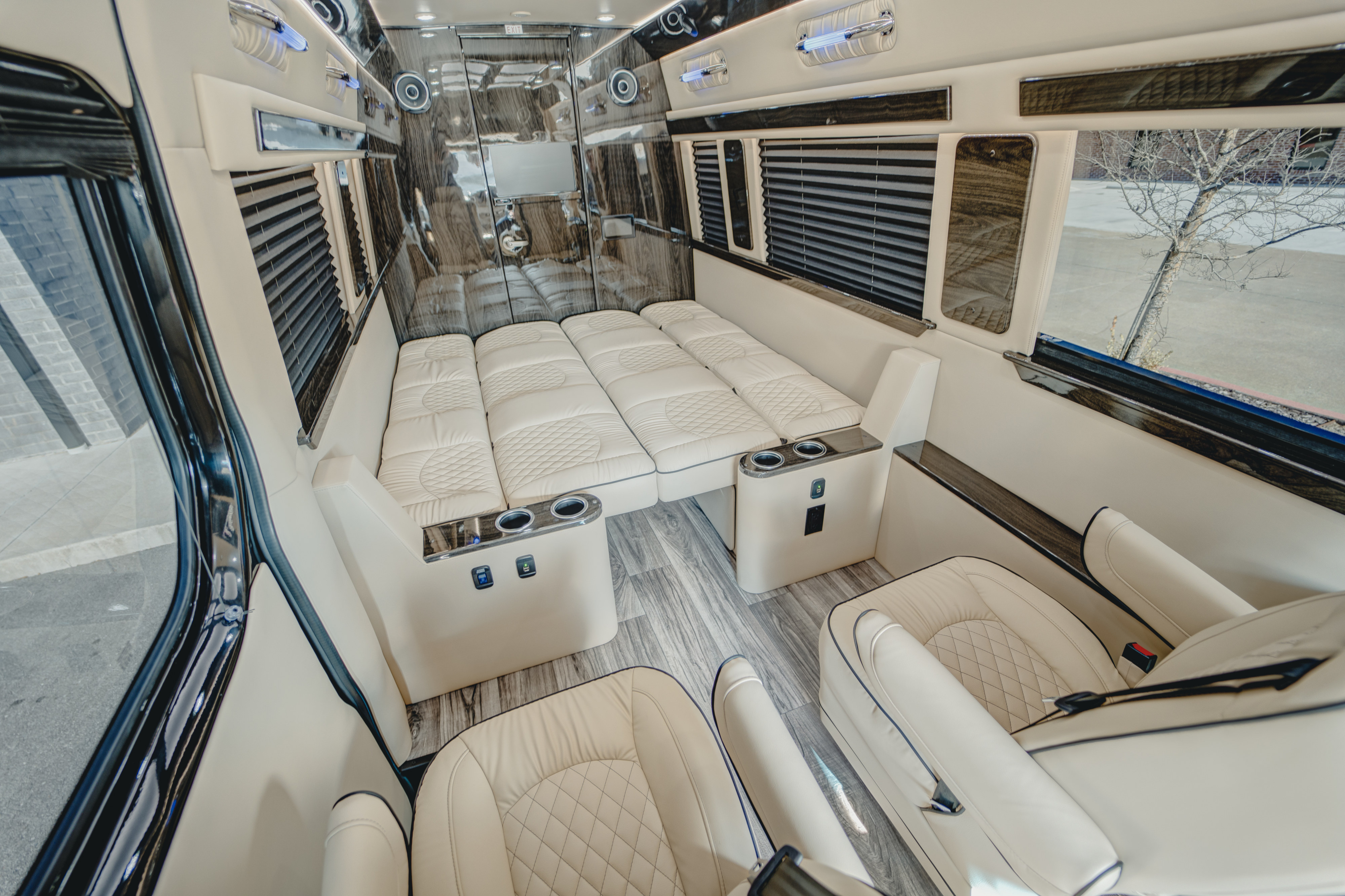 Premium rv rental interior: cream leather seats, a convertible bed, wood accents, and sleek design.. Ultimate Toys Ultimate Traveler 2023