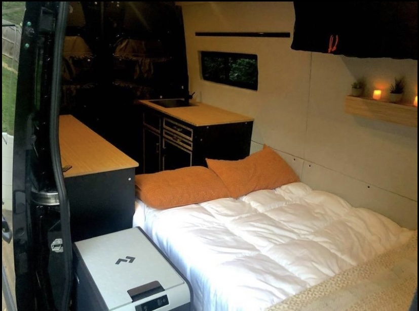 Step into this cozy RV rental: a bed, kitchen, fridge, and charming decor make for ideal mobile living.. Mercedes Sprinter 2021