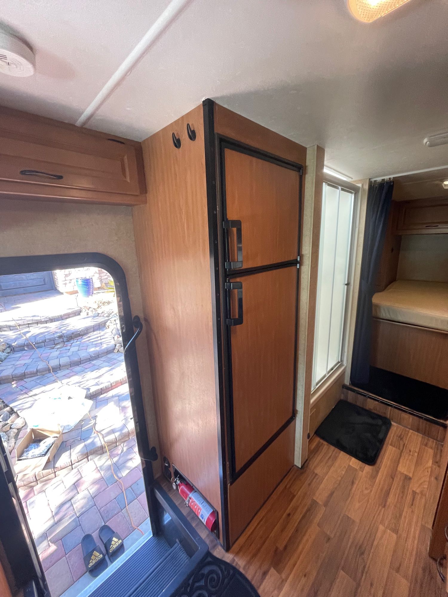 Explore this RV rental's interior: a large refrigerator, shower, bunk beds, and safety features like a fire extinguisher by the door.. Thor Majestic 2018