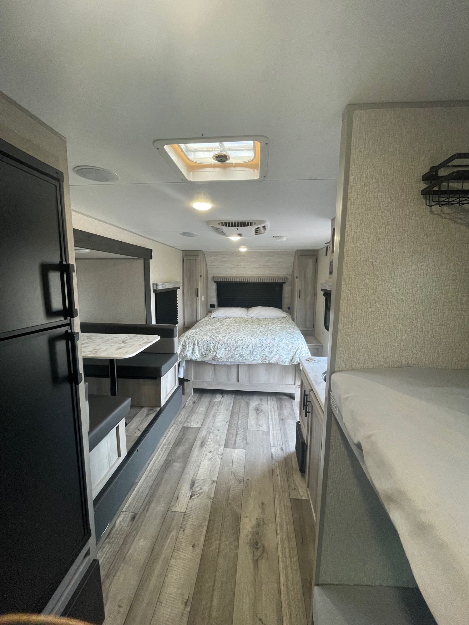 RV rental interior: spacious bedroom, dinette, refrigerator, and bunk beds in a modern camper.. KZ Escape 2022