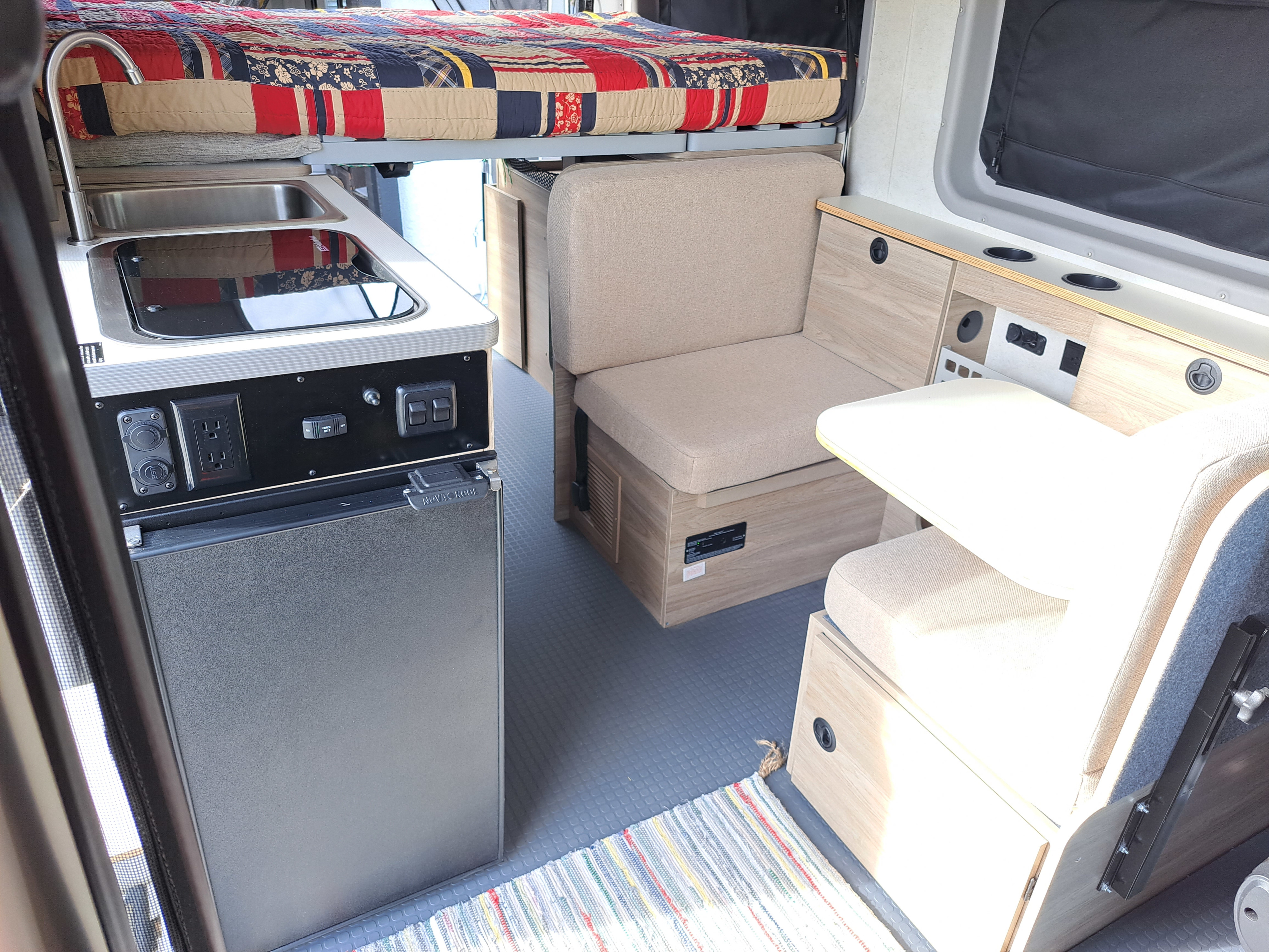 Explore this RV rental's interior: a compact kitchenette, comfortable dinette, and elevated bed optimize space for adventure.. Winnebago Winnebago 2023