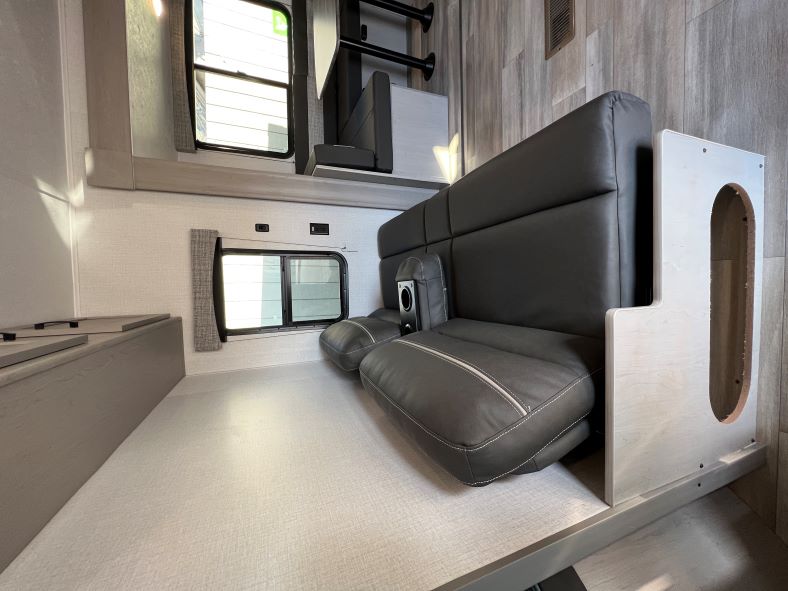 RV rental interior features a gray convertible sofa/bed, large windows, and overhead storage. Ideal for road trips.. Coachmen Clipper 262 BH C 2023