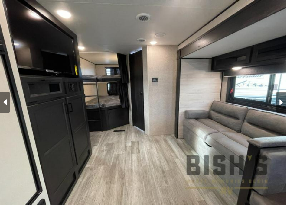 Spacious RV rental interior featuring a cozy sofa, entertainment center, and bunk beds. Perfect for family adventures!. Jay Flight 286BHSW 286BHSW 2023