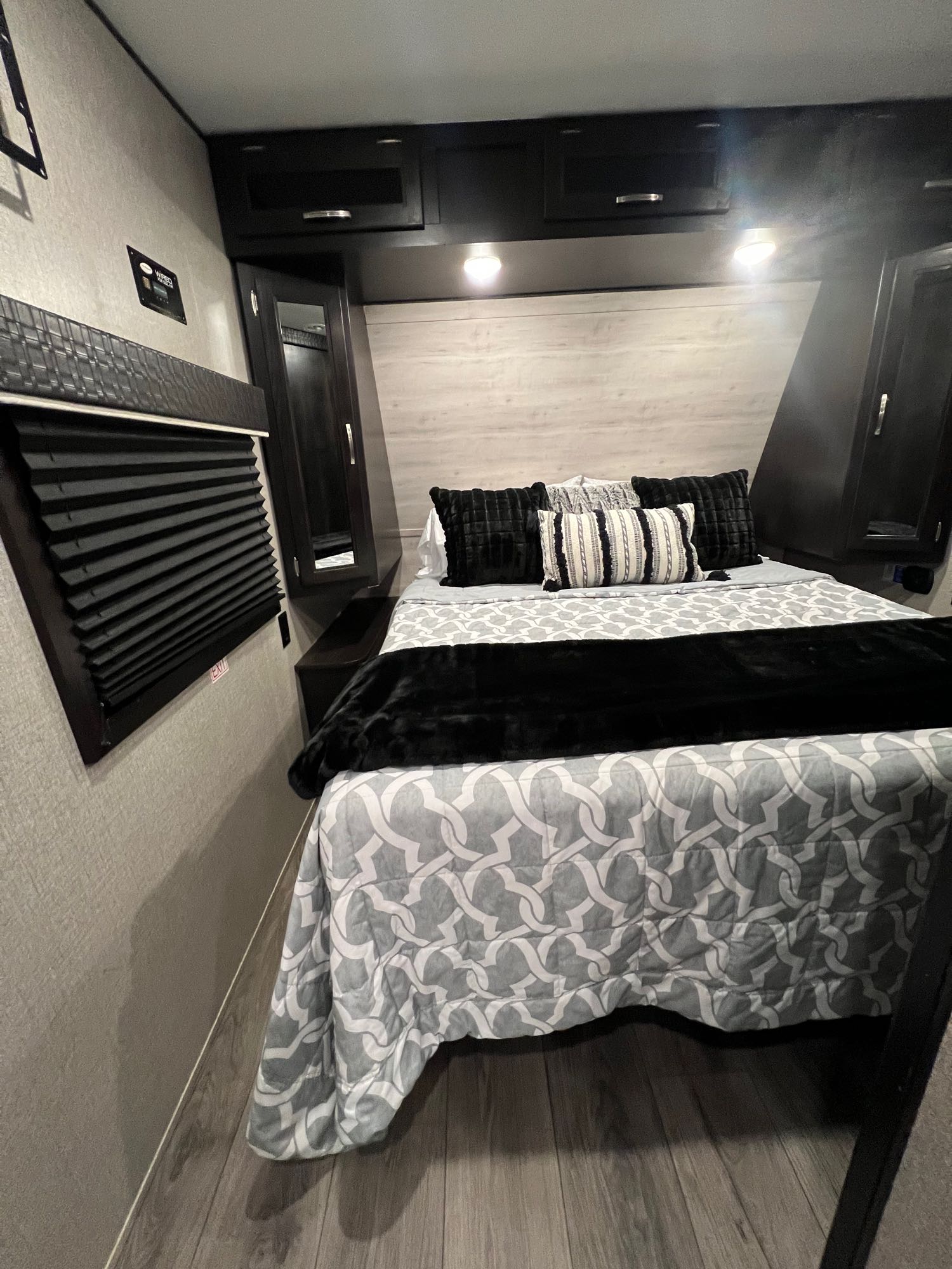 Experience comfort in this RV rental's modern bedroom. Features a queen bed, dark wood cabinets, and ample light.. Jayco Jay Flight 2021