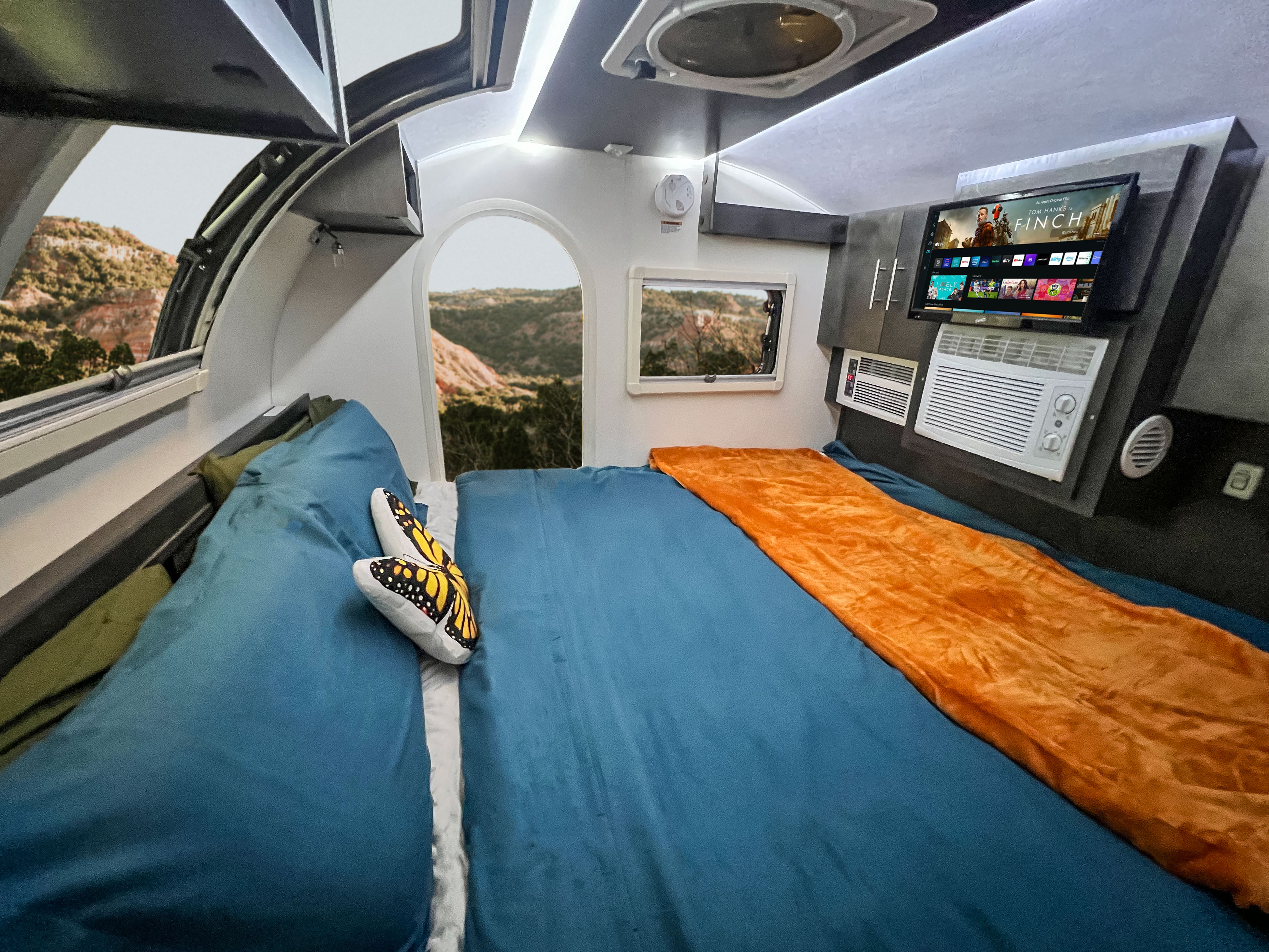 Welcome to the inside! King-size bed, storage, tv with Fire TV Stick & DVD player, heater & A/C, star-gazing window, blinds & screens & ceiling fan.. nuCamp RV T@G XL 2023