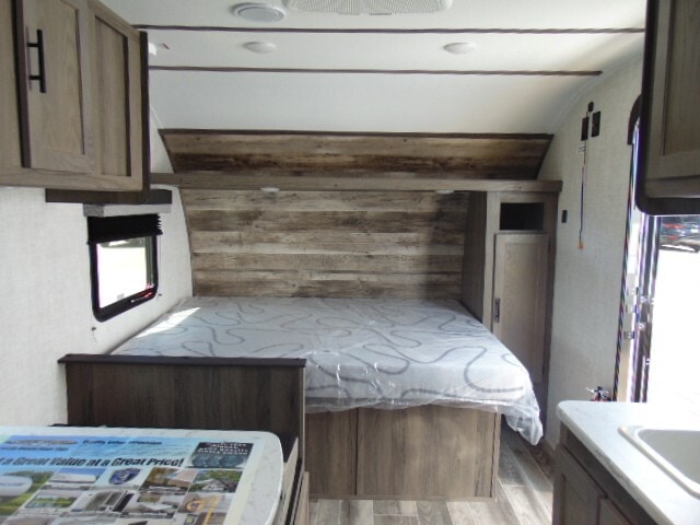 RV rental bedroom area: a cozy bed with wood-paneled headboard, built-in storage, and modern finishes.. Gulf Stream Ameri-Lite Super Lite 2022