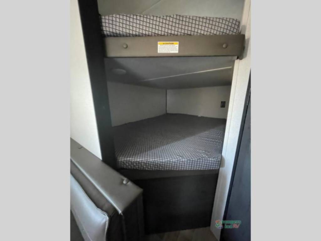 Cozy bunk beds in this RV rental offer two sleeping areas with checkerboard mattresses and a safety rail.. Keystone RV Hideout 2022