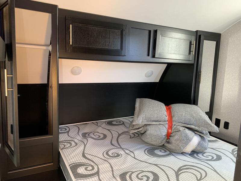 RV rental bedroom: a comfortable bed, ample storage in overhead cabinets & side wardrobes. Ready for your adventure!. Forest River Grey Wolf 26DBH 2022