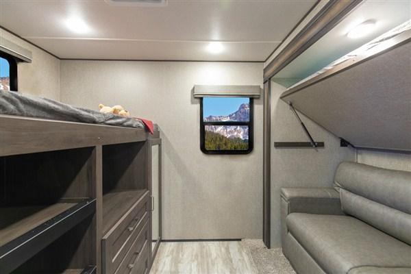 This RV rental's interior boasts comfy bunk beds, a convertible sofa, and a stunning mountain view window, ideal for family travel.. Grand Design Reflection 2021