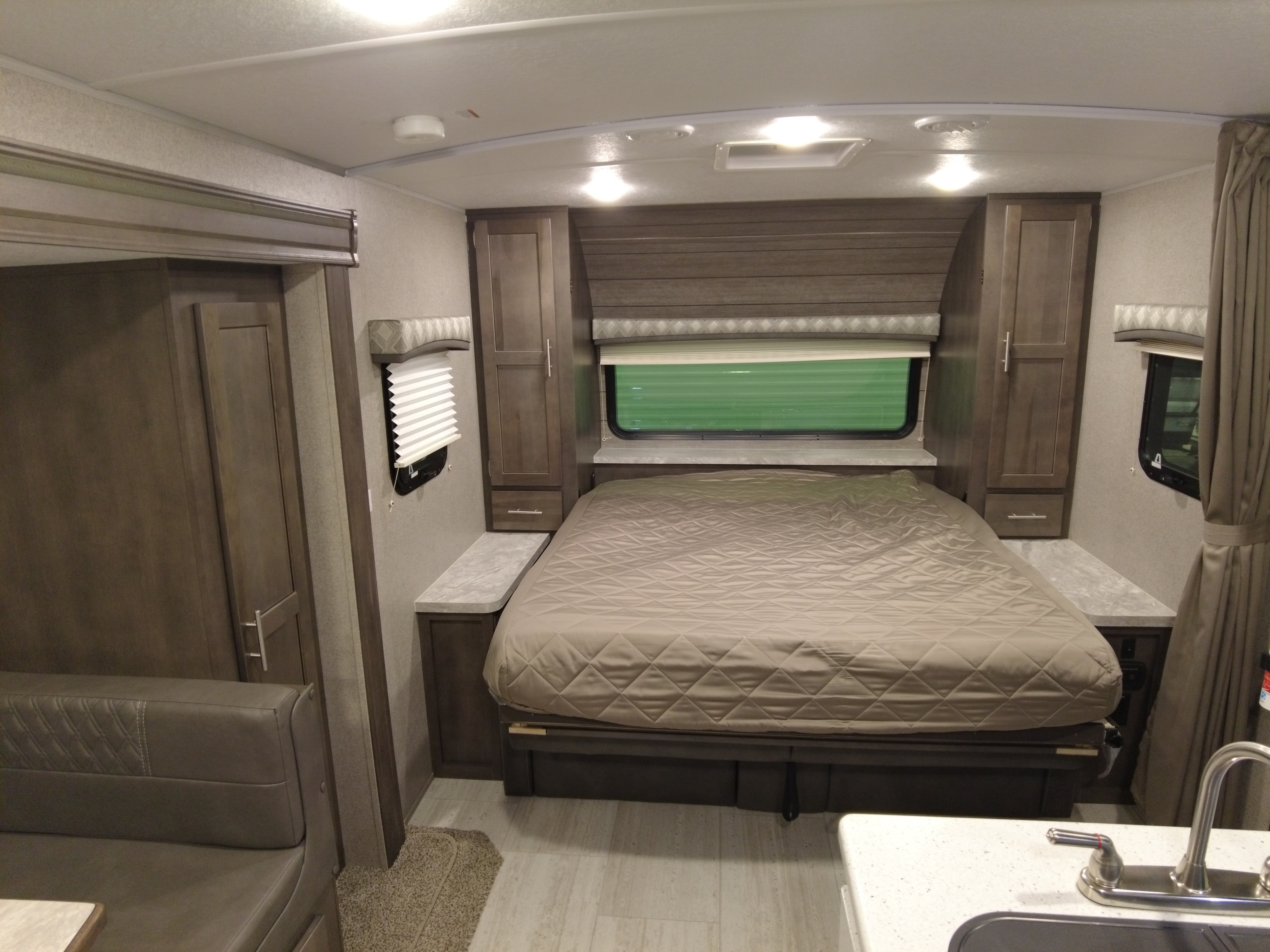 Step inside this modern RV rental featuring a comfortable bedroom, storage, and adjacent living space.. Forest River Flagstaff Micro Lite 2021