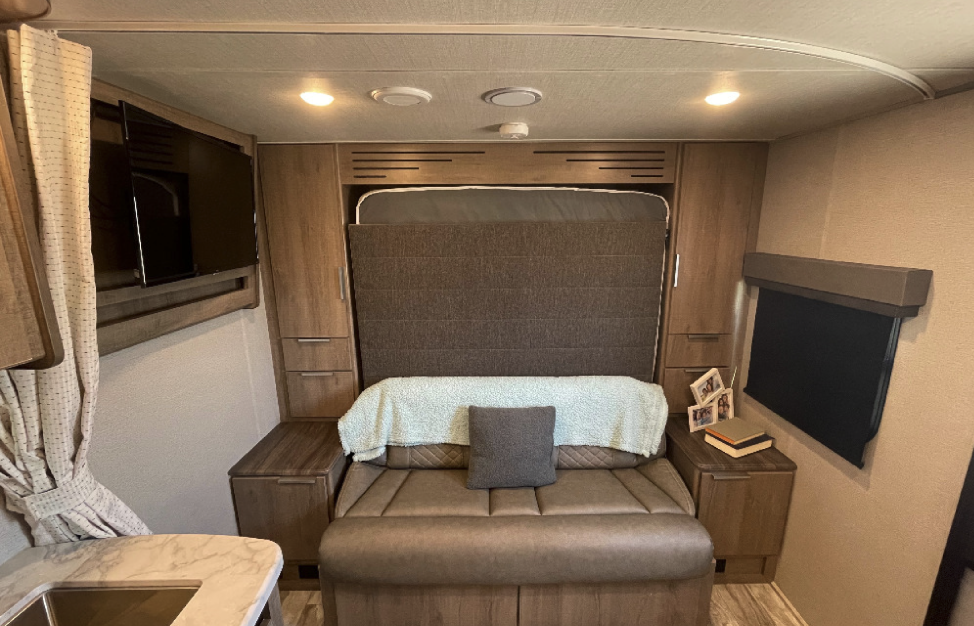 RV rental interior featuring a murphy bed, sofa, TV, and storage for a cozy stay.. Grand Design Imagine XLS 21BHE 2022