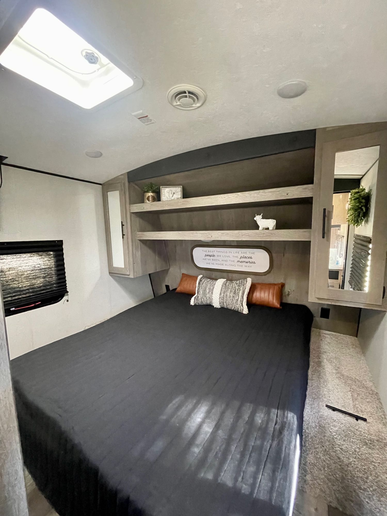Organized RV rental bedroom features a comfy bed, overhead storage, and skylight for bright travels.. Keystone RV Springdale 2021
