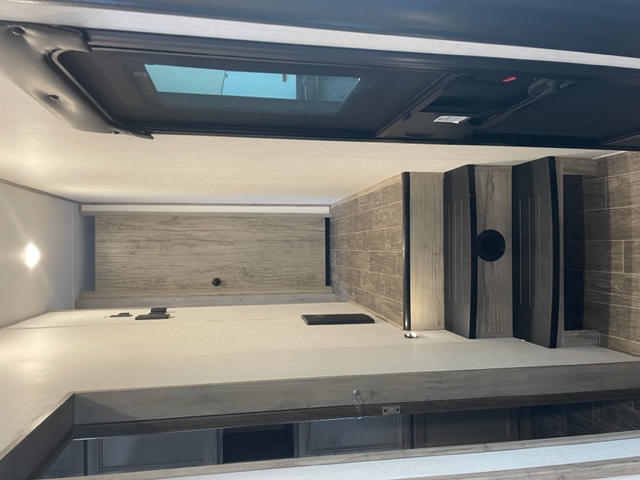 Bright, modern RV rental interior with a skylight and steps leading to an upper area. Perfect for your next adventure!. Forest River Cherokee Arctic Wolf 2022