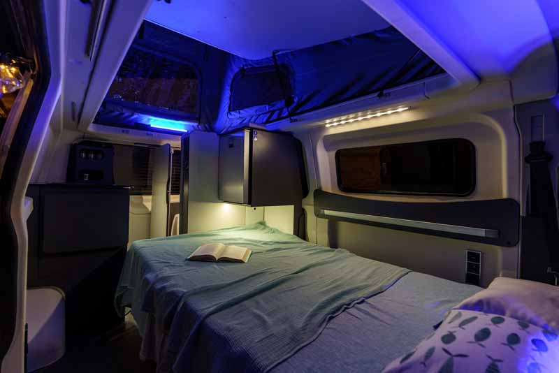 Cozy RV rental camper van interior. Features a comfy bed, warm & blue ambient lighting for a relaxing night.. Ford Randger R530 2022