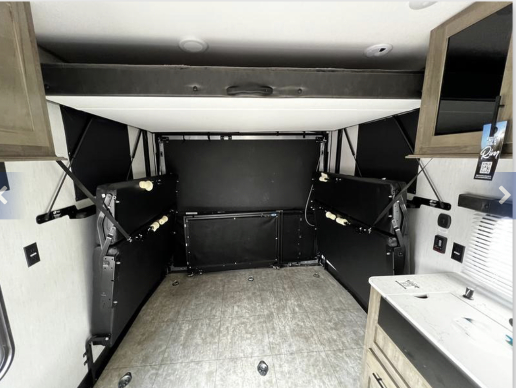 Spacious RV rental interior features fold-up beds & a top bunk, optimizing space for cargo or living.. Forest River Vengeance 2022