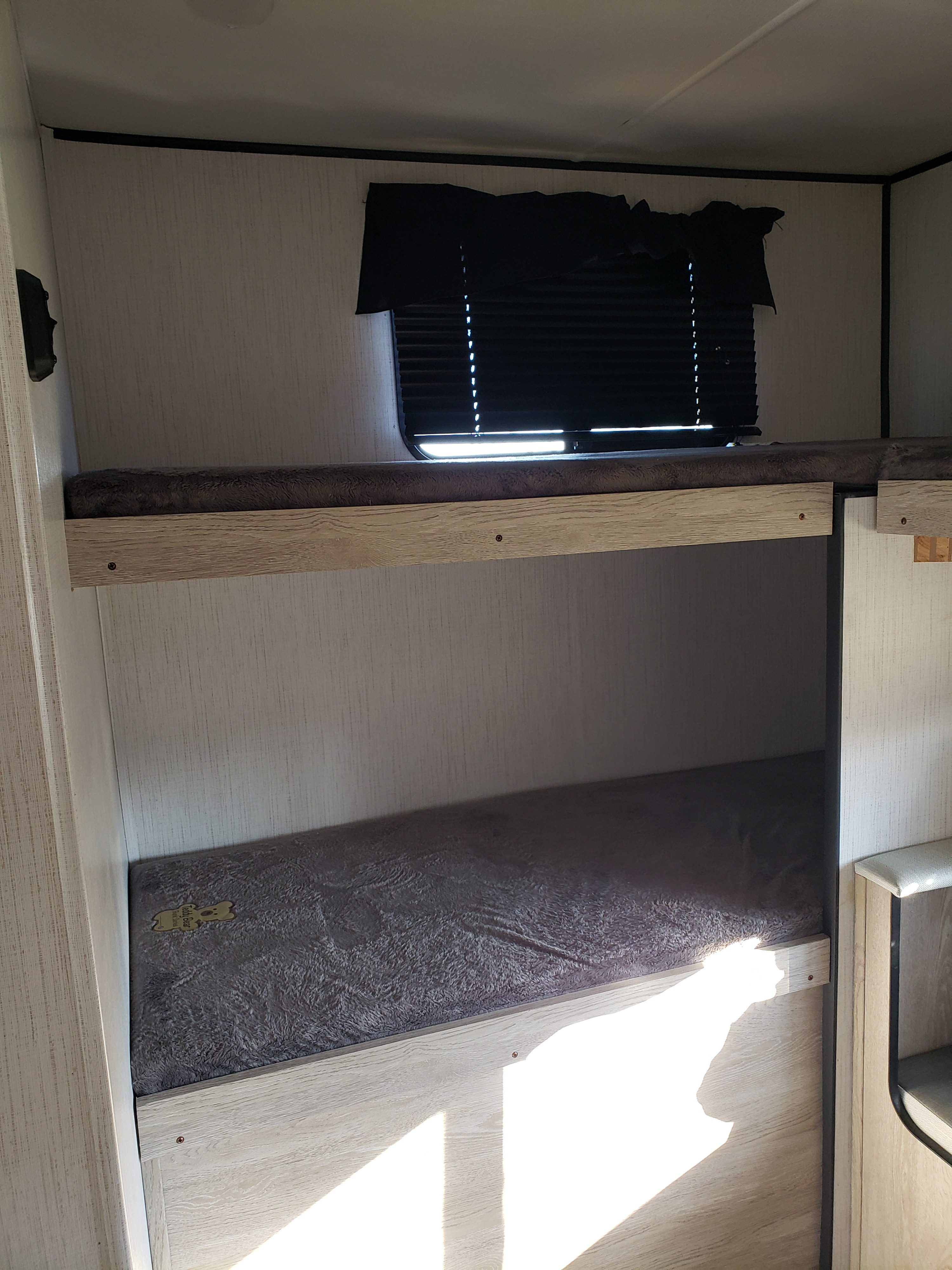Cozy RV rental bunk beds with light wood frames & soft mattresses for comfortable interior sleeping.. Heartland RVs Prowler 2022