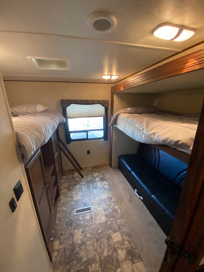 RV rental bunkhouse interior: Multiple beds, sofa, and window offer comfortable RV accommodations.. Crossroads RV Zinger 2013