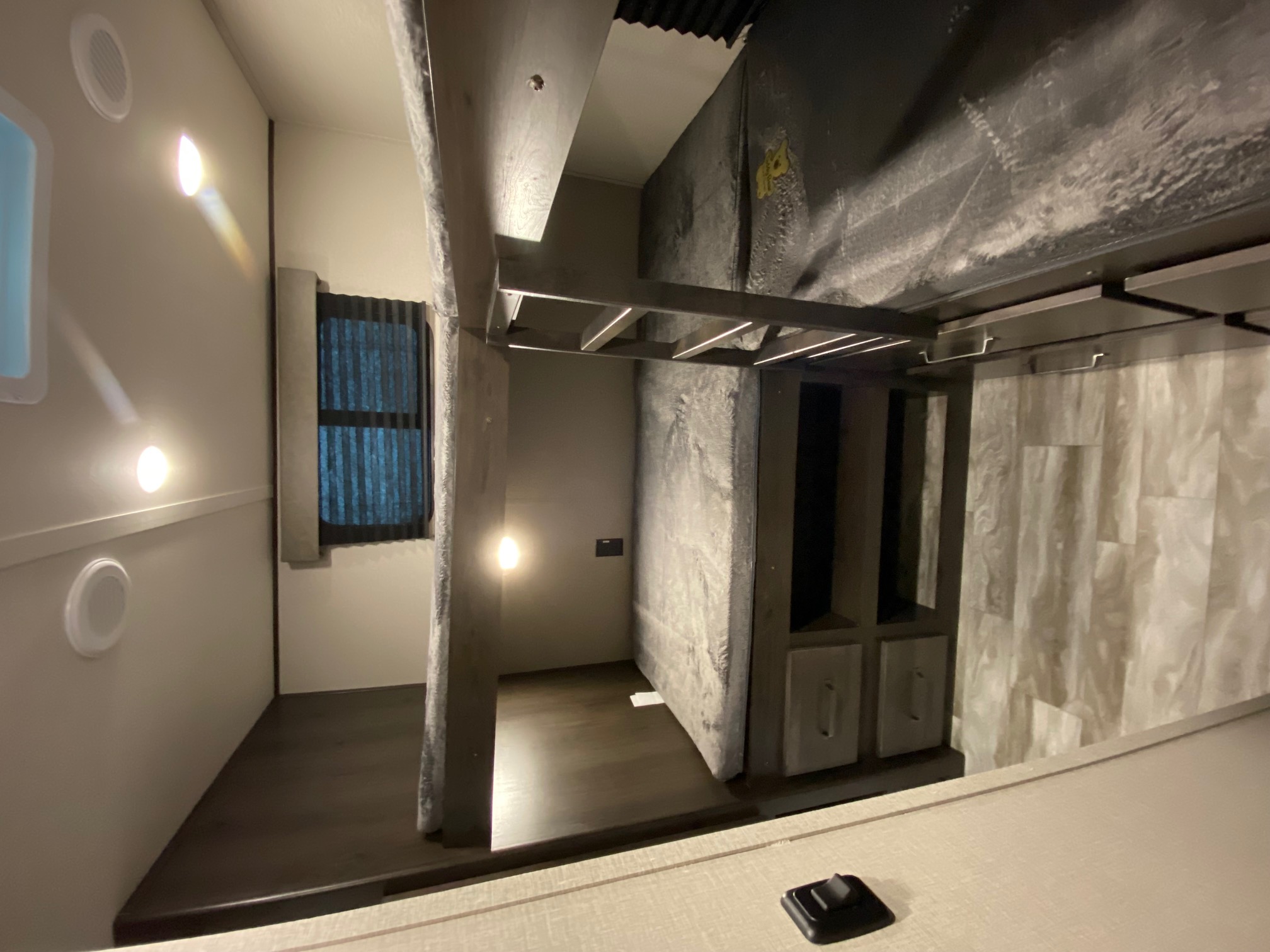 Modern RV rental interior with sleek gray bunk beds, bright lighting, and a clean, spacious living area.. Grand Design Transcend Xplor 2022