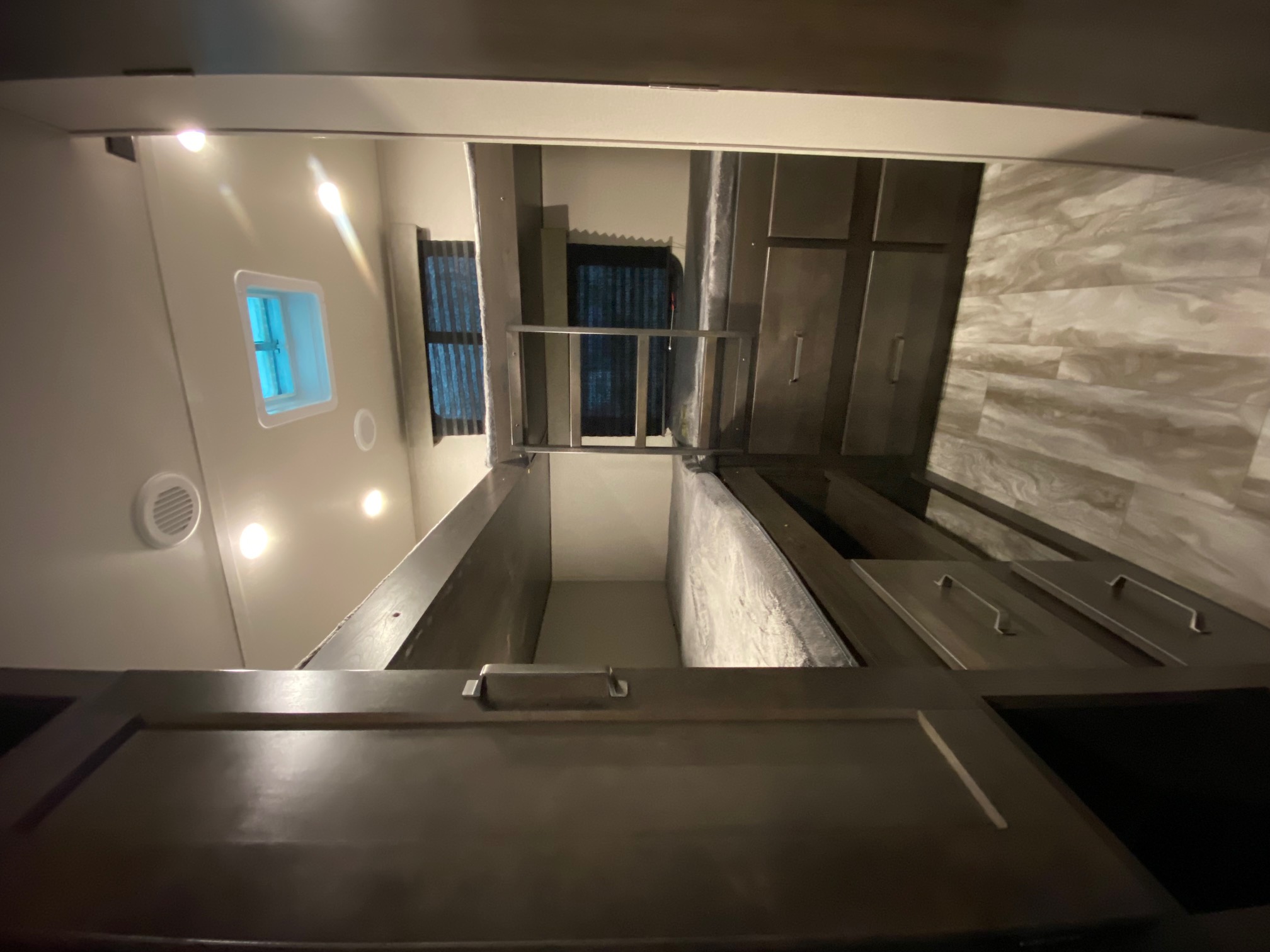 RV rental: Inside a cozy RV, stacked bunk beds with safety rail, window, and storage drawers/cabinets.. Grand Design Transcend Xplor 2022