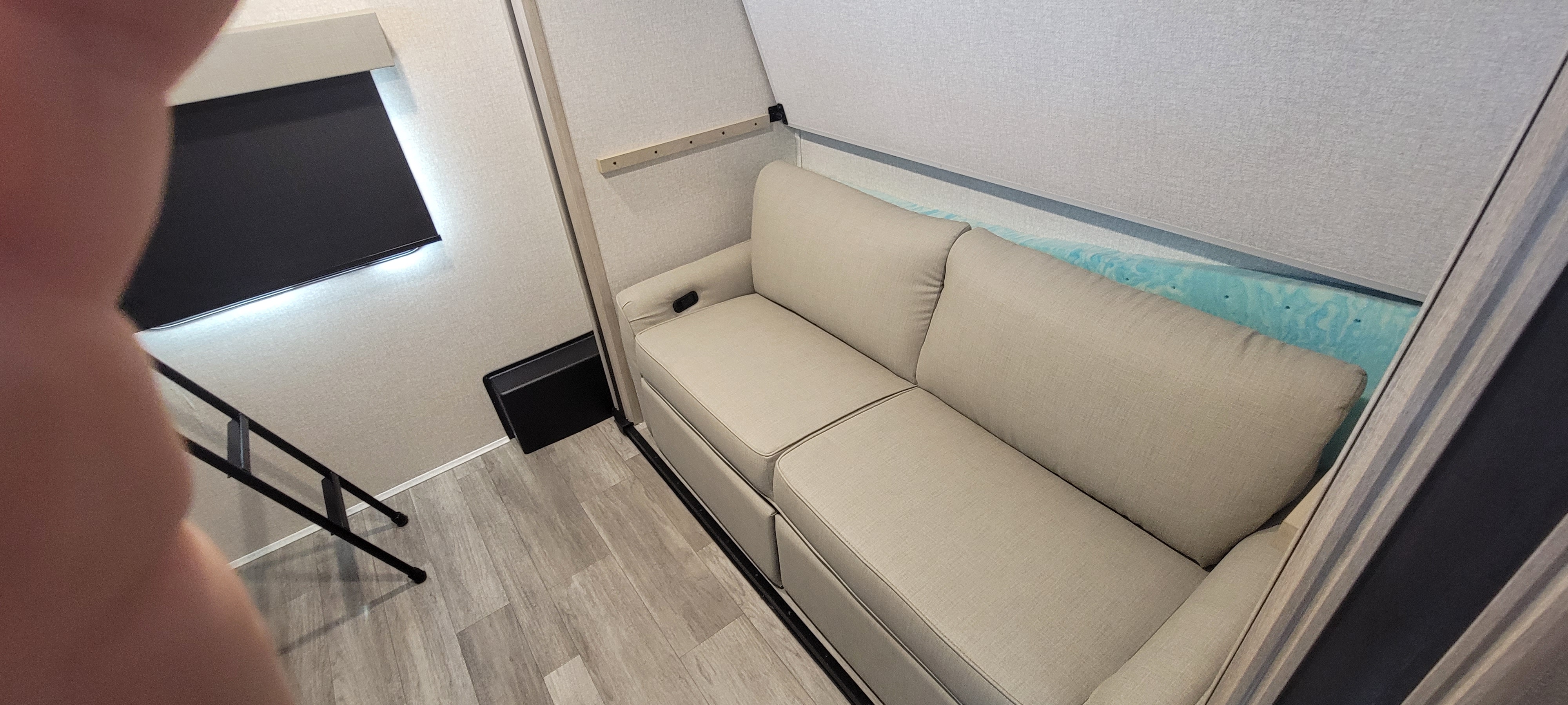 RV rental: Bright interior with beige sofa, blue bunk mattress, dark blind, and bunk ladder. Cozy space for travel.. East to West Alta 2022