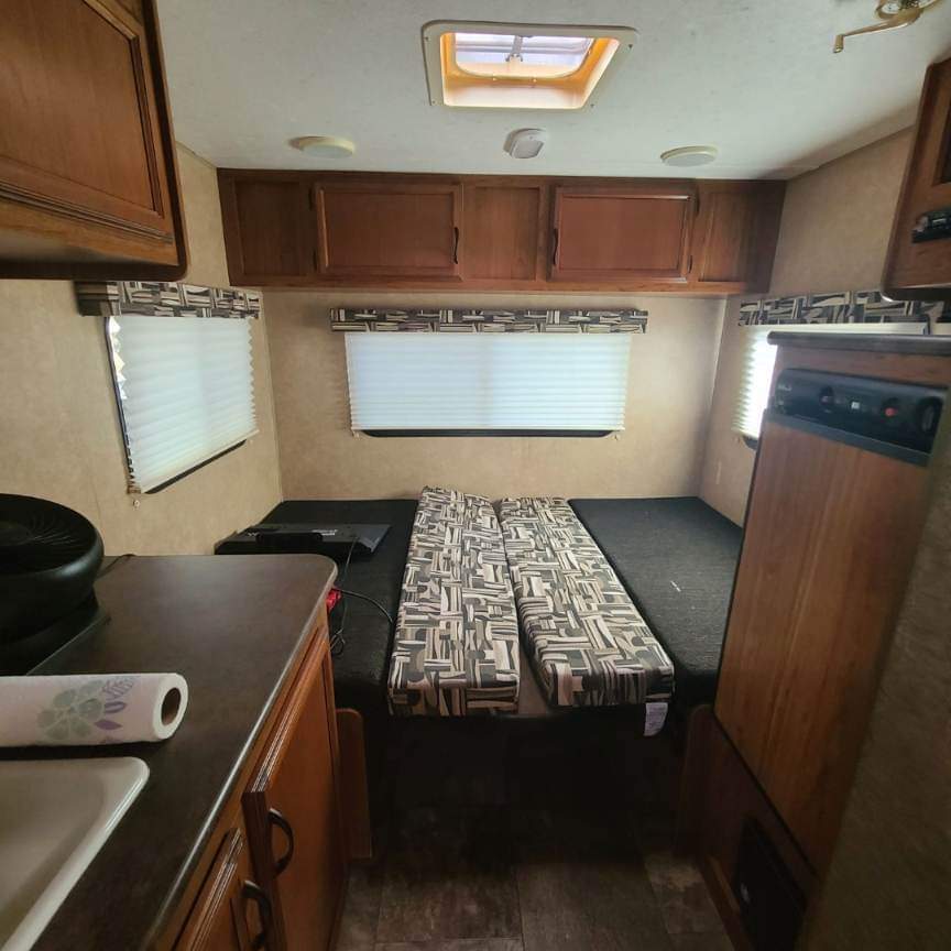Bright rv rental interior: kitchen, convertible bed, overhead cabinets, and skylight. Ready for adventure.. Starcraft AR-One 2015