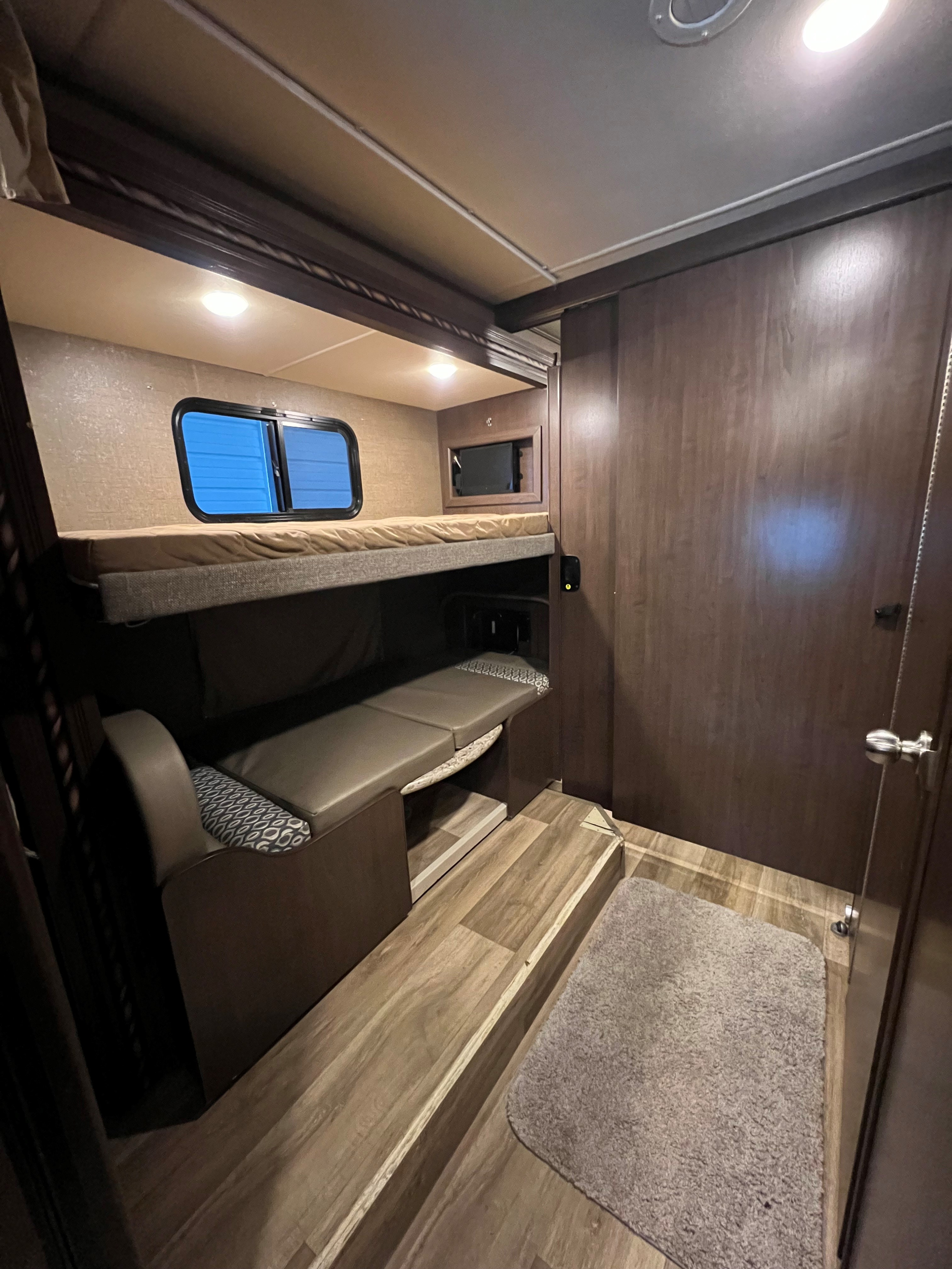 RV rental interior: bunk beds with window, built-in screen, & versatile lower seating perfect for travel.. Thor Freedom Elite 2017