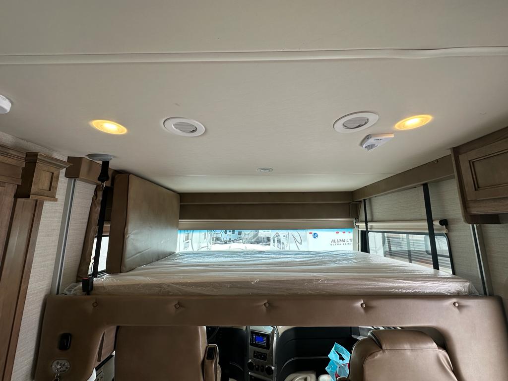 RV rental interior: Front overhead bunk with mattress, recessed ceiling lights, and wood cabinets are visible in this spacious camper.. Jayco Precept 2019
