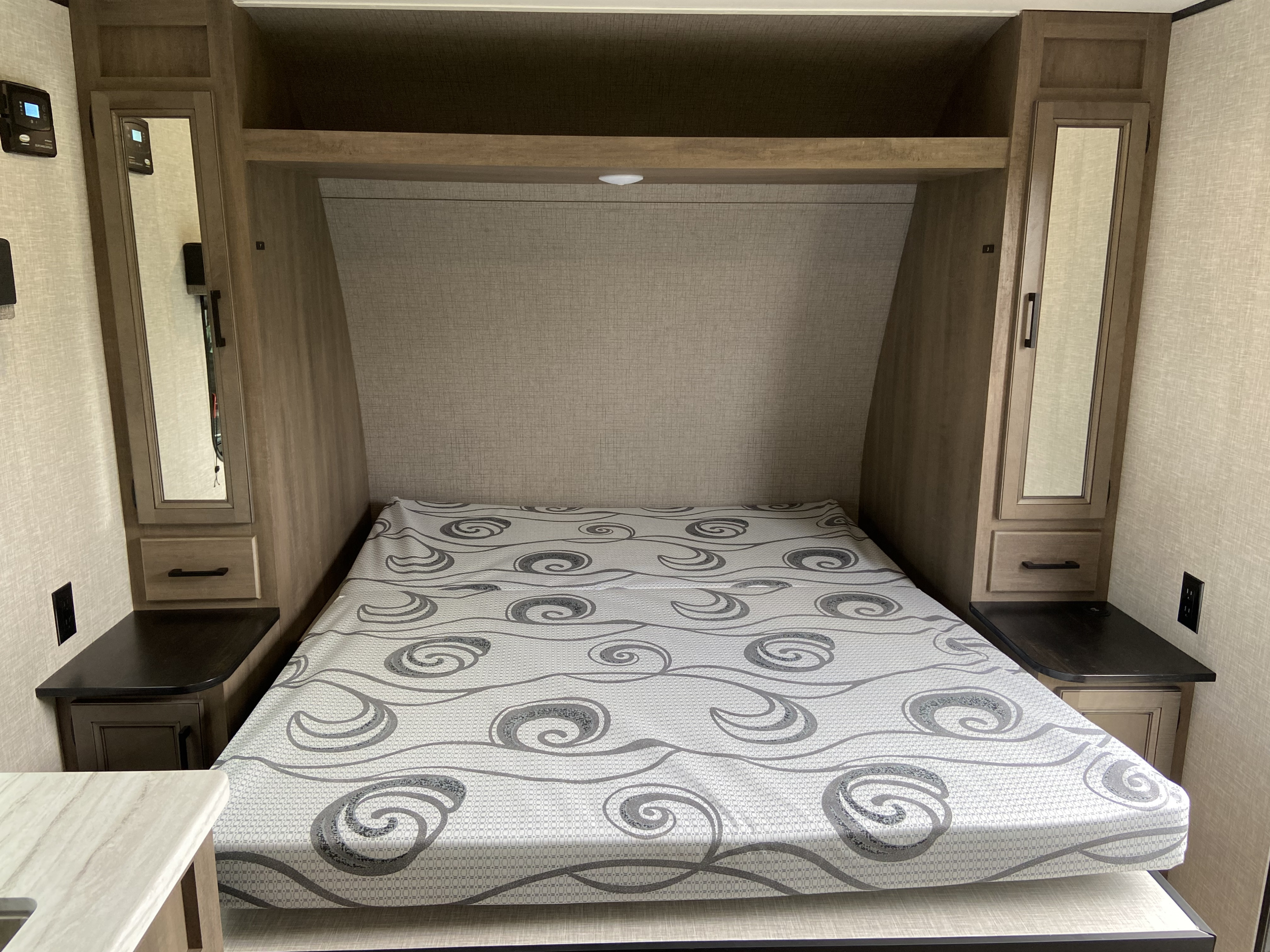 This RV rental bedroom offers a comfortable bed, mirrored wardrobes, and overhead shelf storage for your travels.. StarCraft Autumn Ridge MB20 2023
