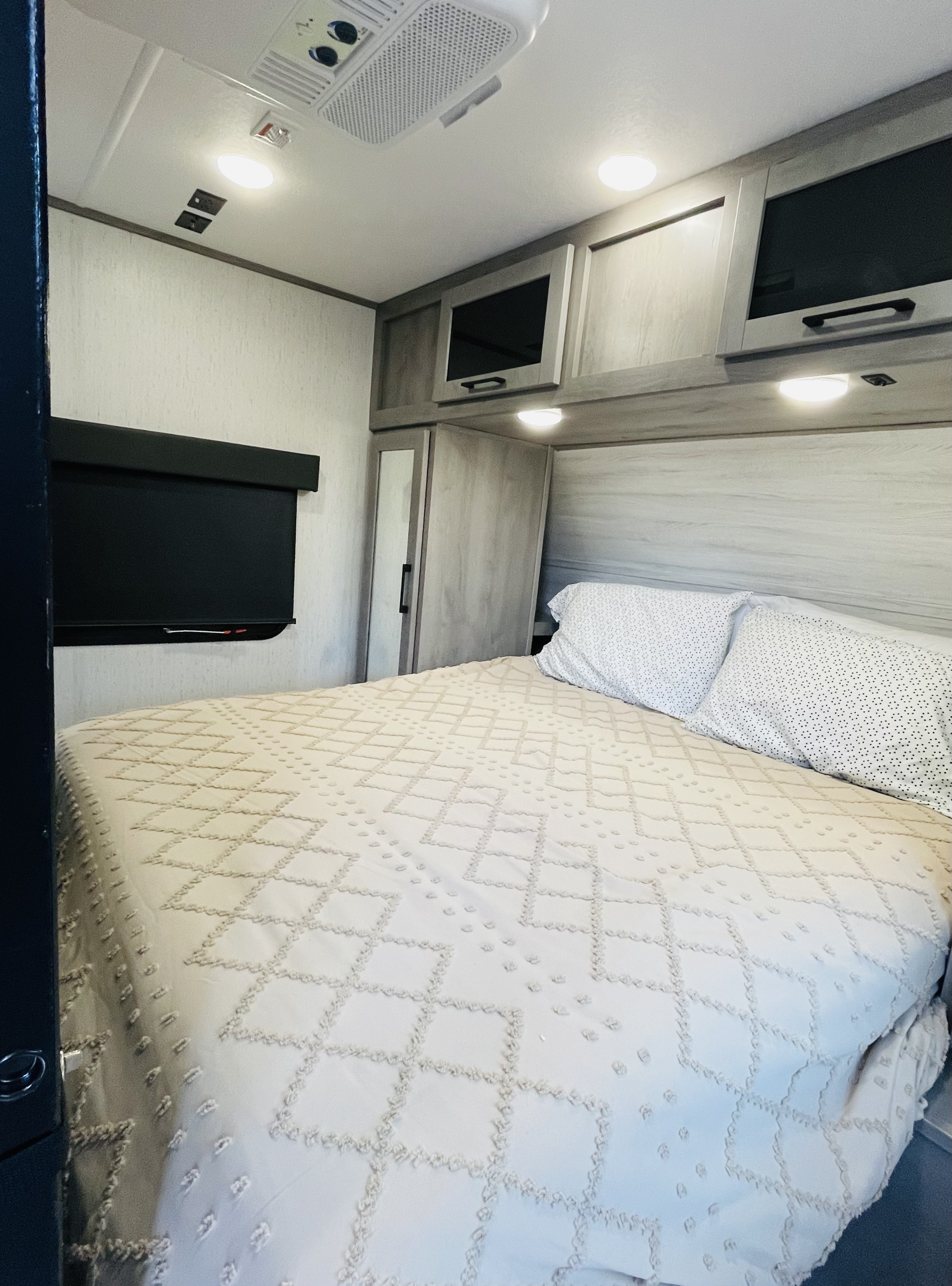 Comfortable RV rental bedroom featuring a cozy bed, overhead storage, and a window shade for a relaxing trip.. Dutchmen Kodiak Ultra Lite 2021