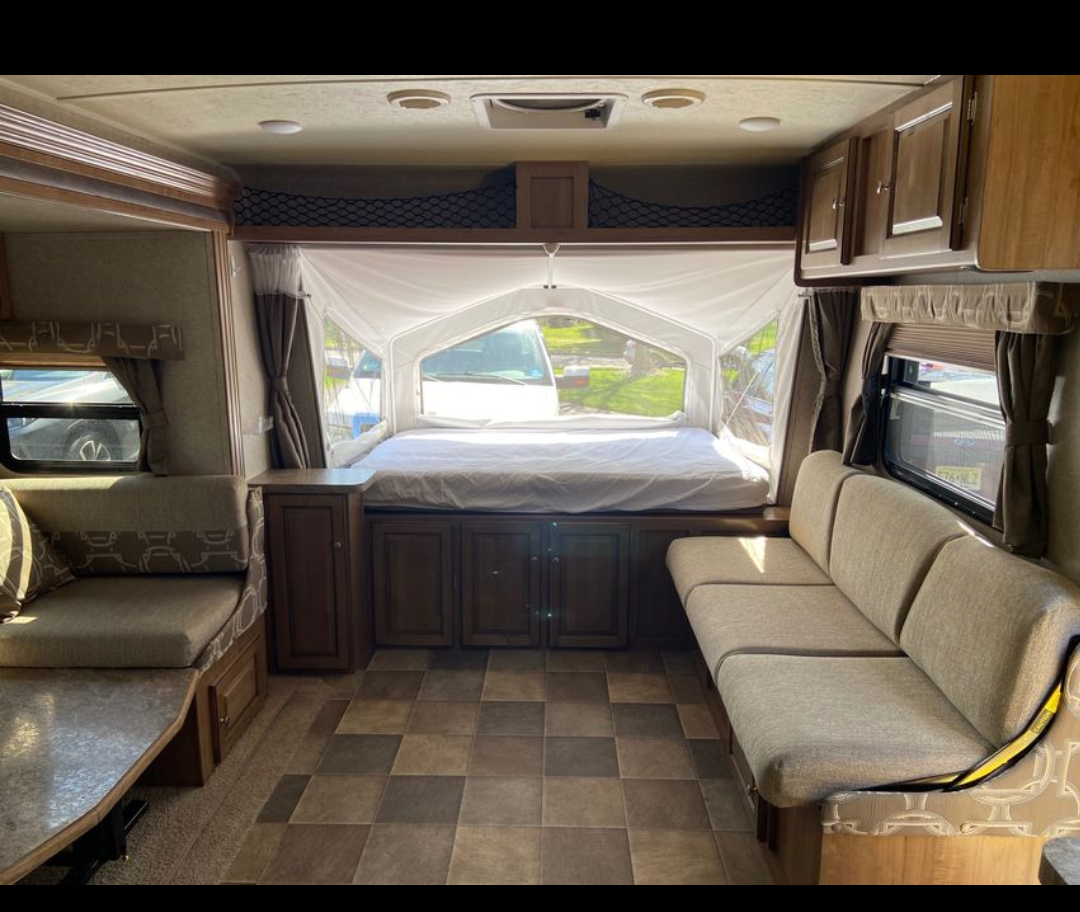 Bright RV rental interior featuring a pop-out bed, dinette, and sofa. Perfect for your next camper adventure!. Forest River Flagstaff Shamrock 2016