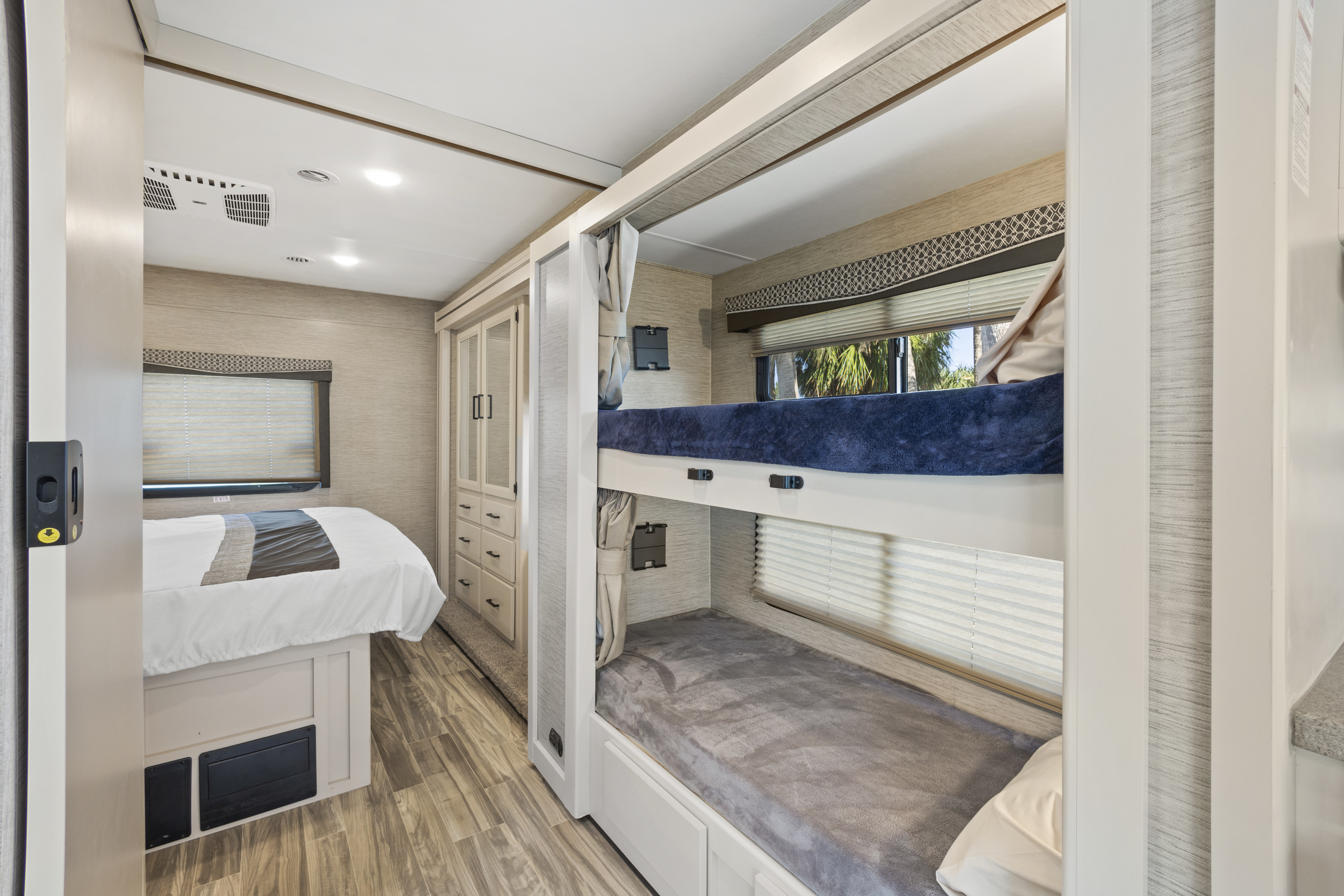 RV rental bedroom area with a master bed, built-in closet, and bunk beds, offering ample space and comfort.. Thor Motor Coach A.C.E 2023