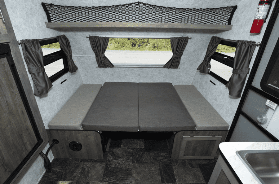 This cozy rv rental interior features convertible beds, windows, overhead storage, and a small sink area.. Prolite XTreme 2019
