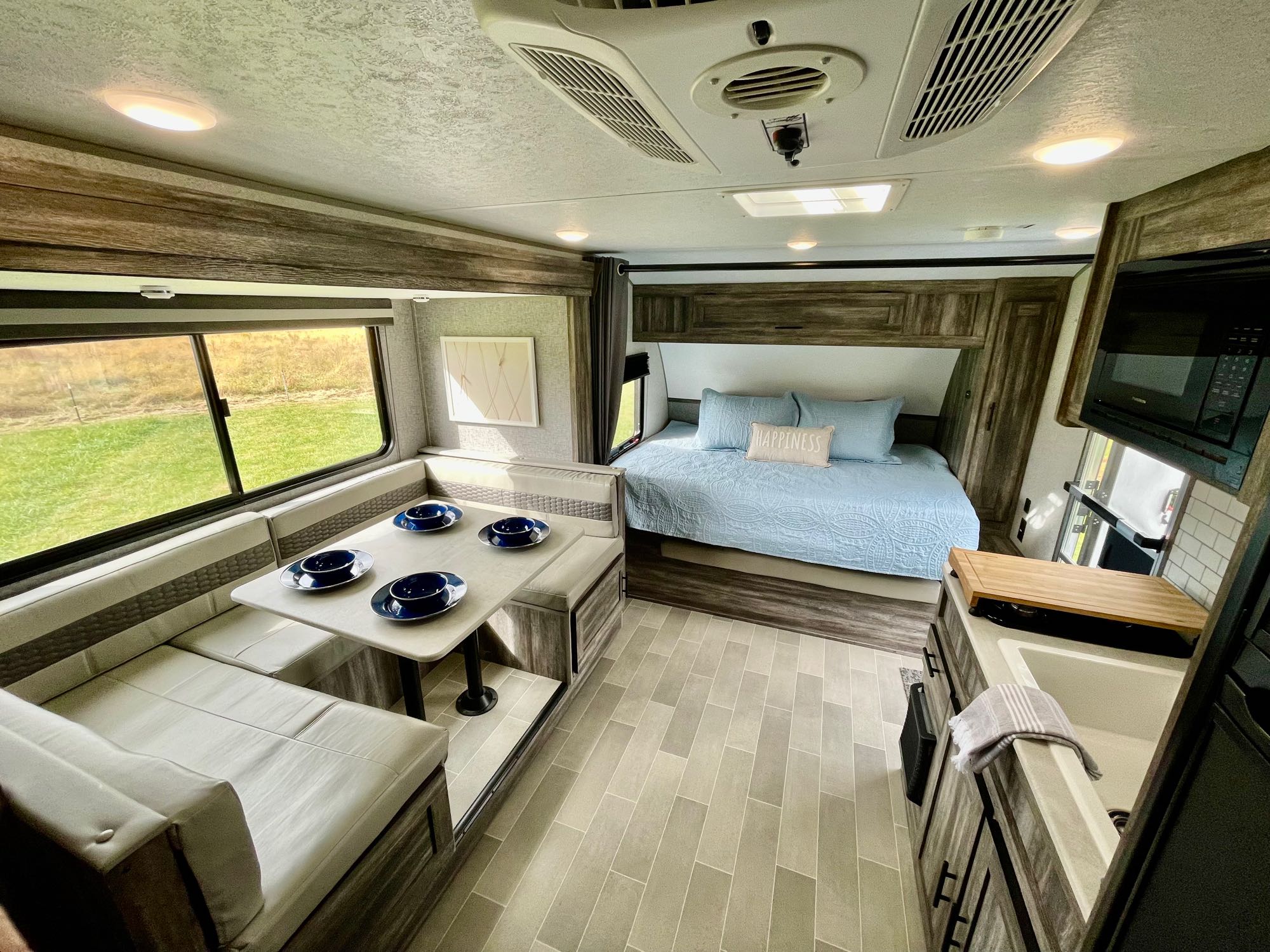 Bright, modern RV rental interior showing a dinette, cozy bed, and functional kitchenette. Ideal for travel.. Forest River Salem FSX PLATINUM 2020