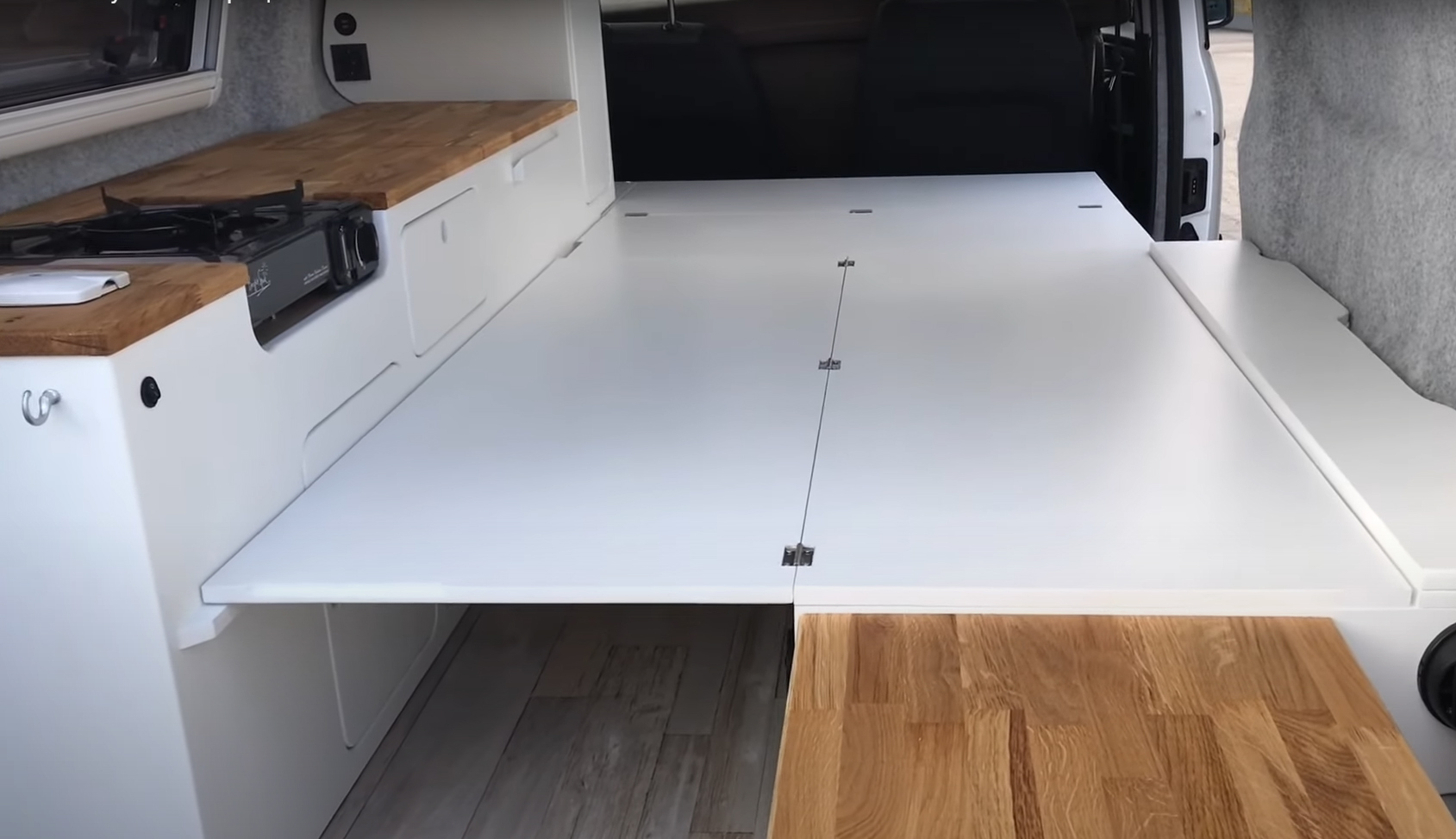 Versatile RV rental camper van interior featuring a folding bed platform, integrated kitchenette, and smart storage.. volkswagen Caddy 2010