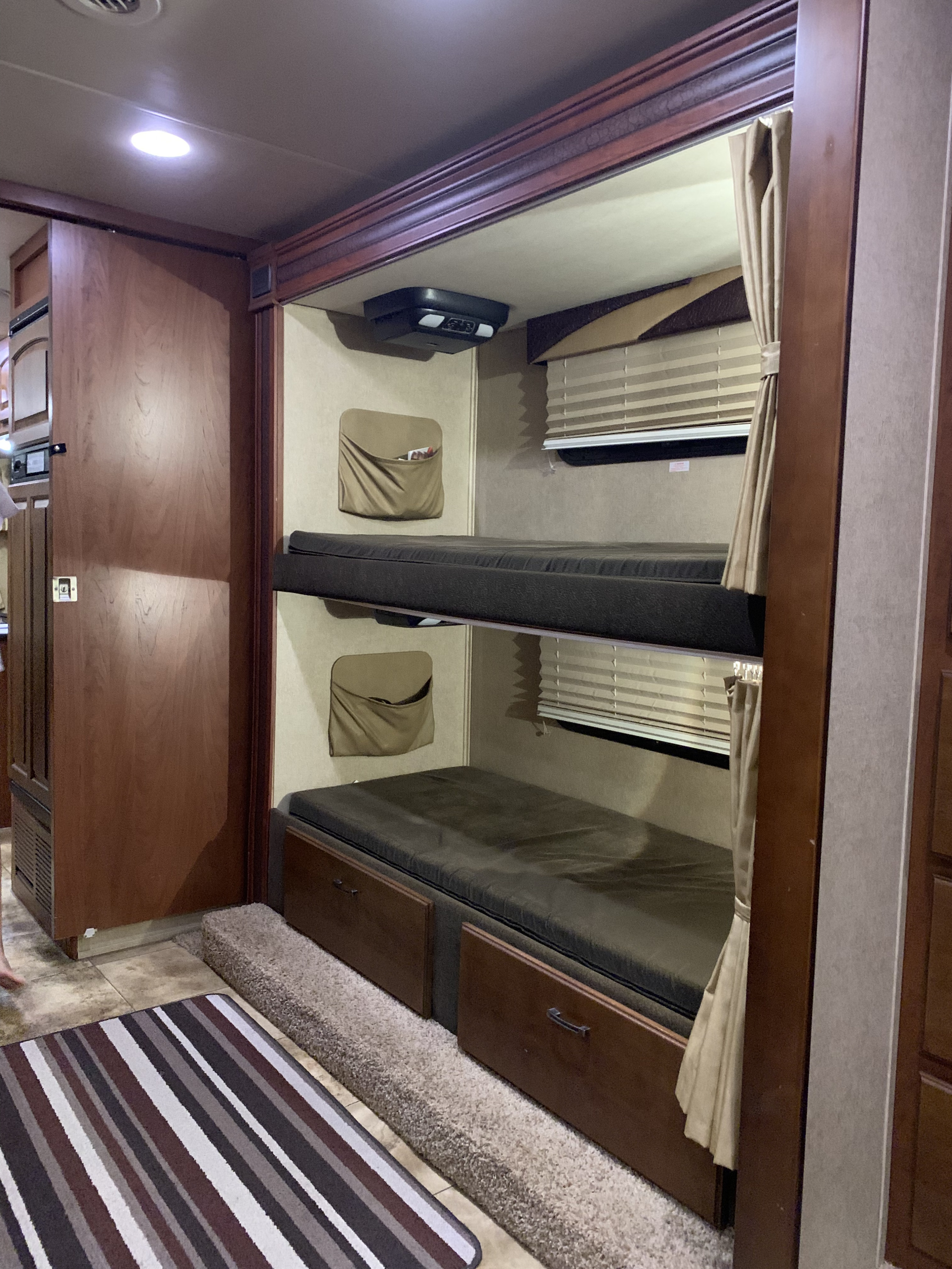 Explore this RV rental's clever interior design featuring comfortable bunk beds with storage and window blinds.. Jayco Greyhawk 2014