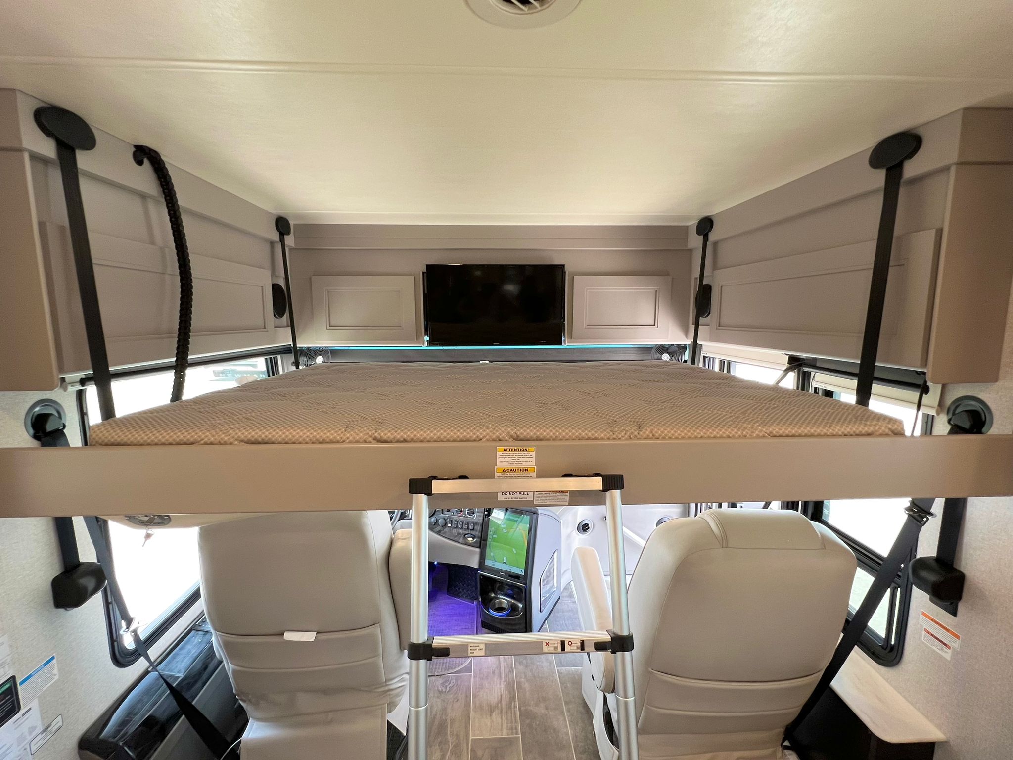 This RV rental features a cozy overhead bunk bed, ladder, TV, and front cabin seats, offering extra sleeping space.. Thor Motor Coach Venetian 2023