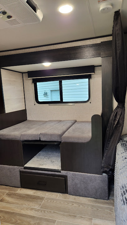 Inside this RV rental: a modern camper featuring a gray upholstered sleeping/seating area, storage drawer, and window.. Jayco Jay Flight SLX STX Edition 2022