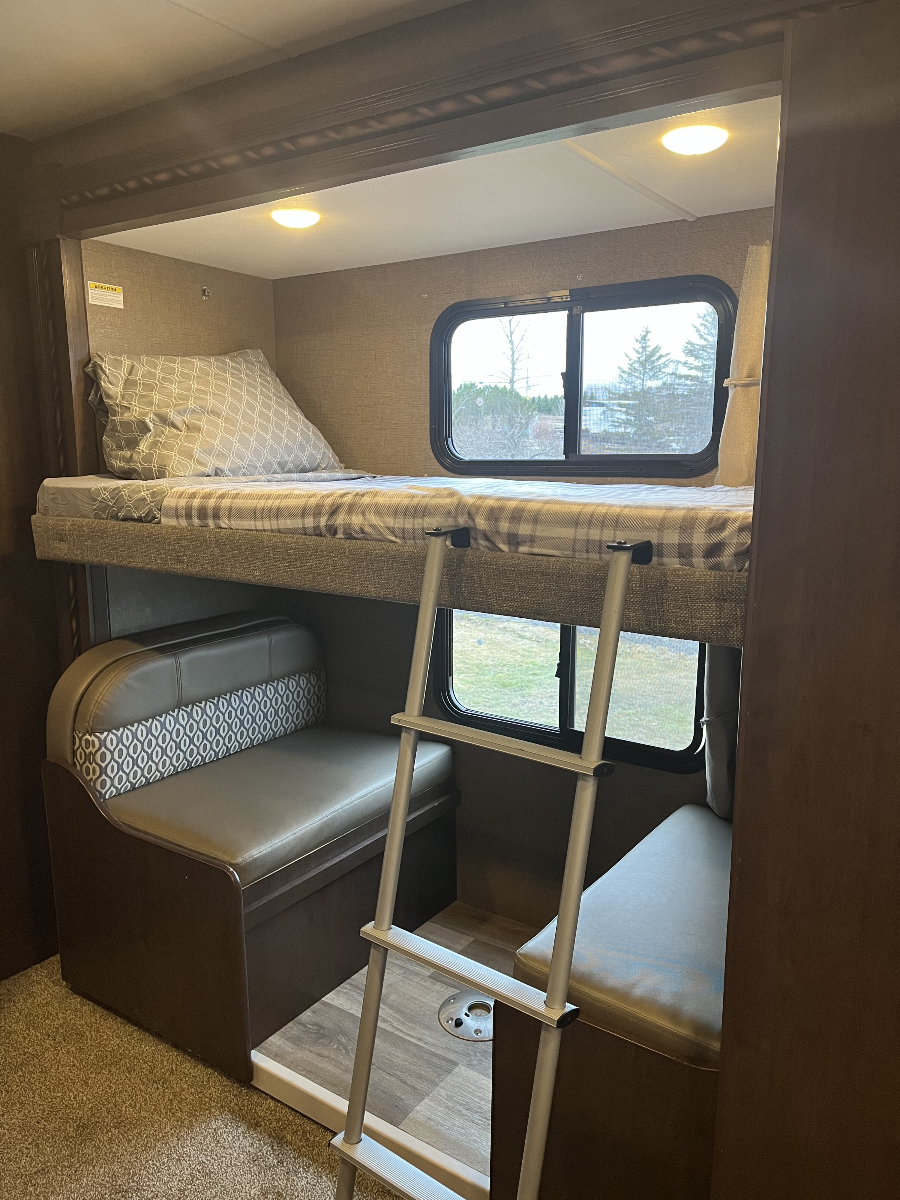 Step into comfort! This RV rental features a cozy bunk bed with a ladder above a convertible dinette seating area.. Thor Freedom Elite 2017