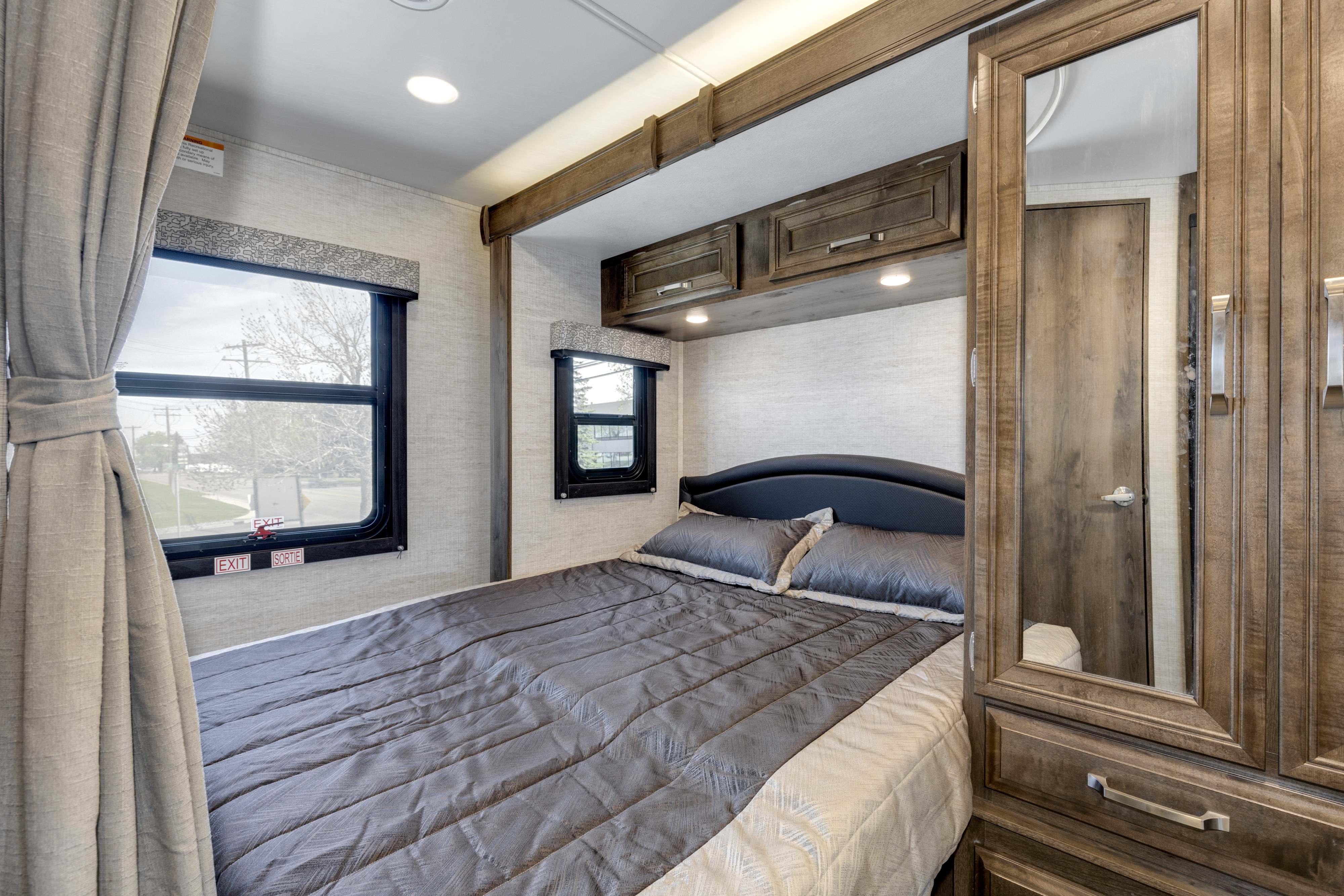 Step inside this cozy RV rental bedroom, featuring a comfortable bed, dual windows, and ample built-in storage.. Jayco Melbourne 2022