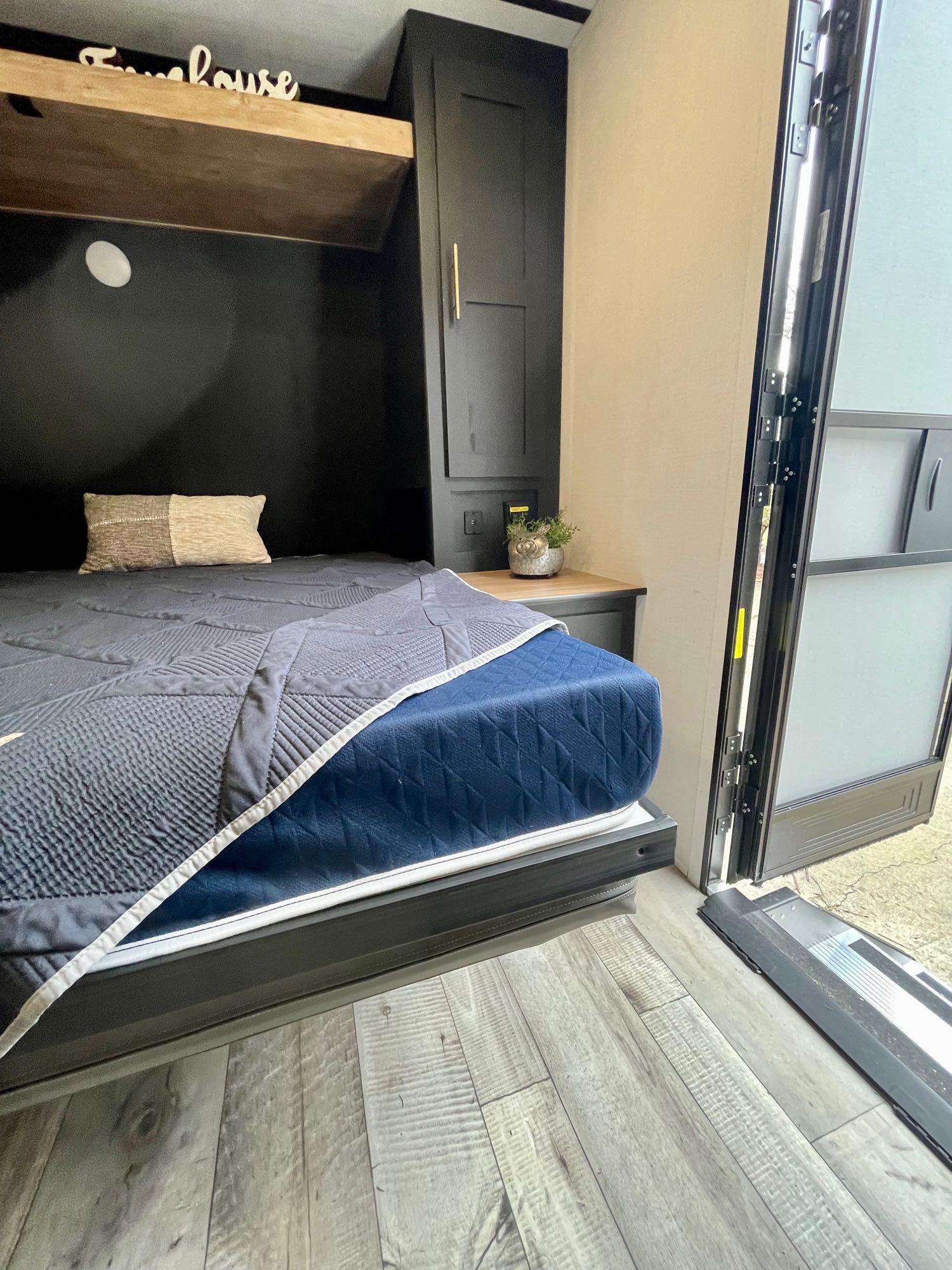 Cozy RV rental interior featuring a comfortable bed, modern cabinetry, and an open door for an inviting space.. Keystone RV Springdale Mini 1810BH 2023