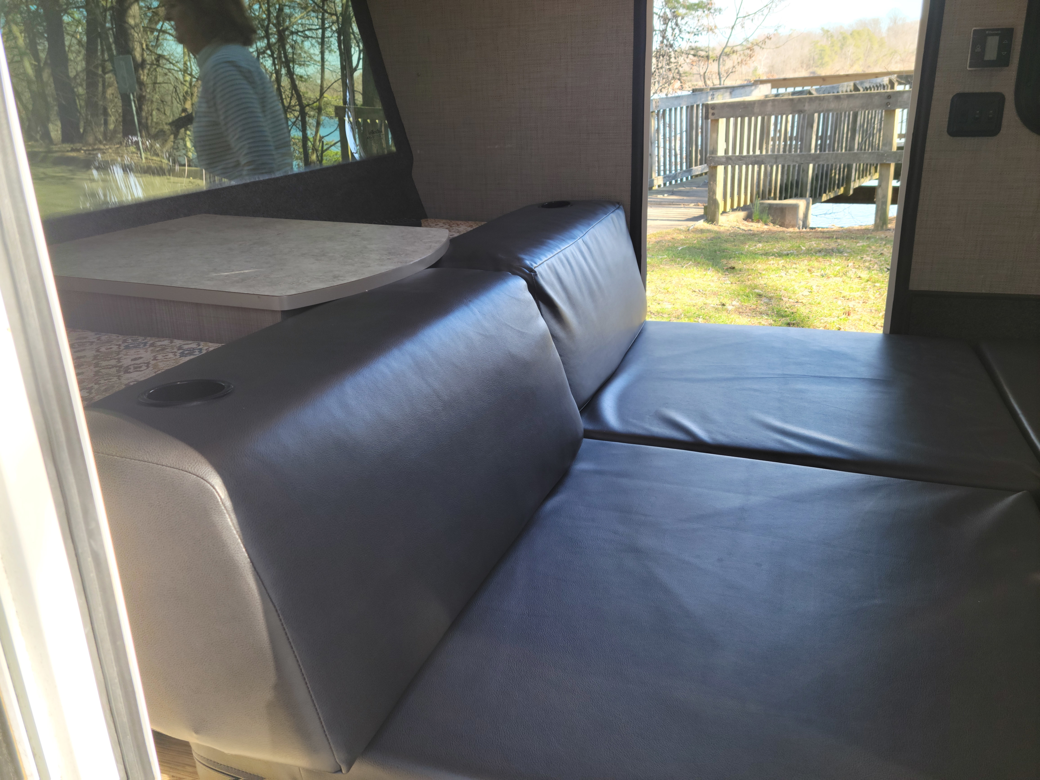 This RV rental interior features a convertible leatherette sofa/bed and dinette, with serene outdoor views.. Intech Luna Rover 2018