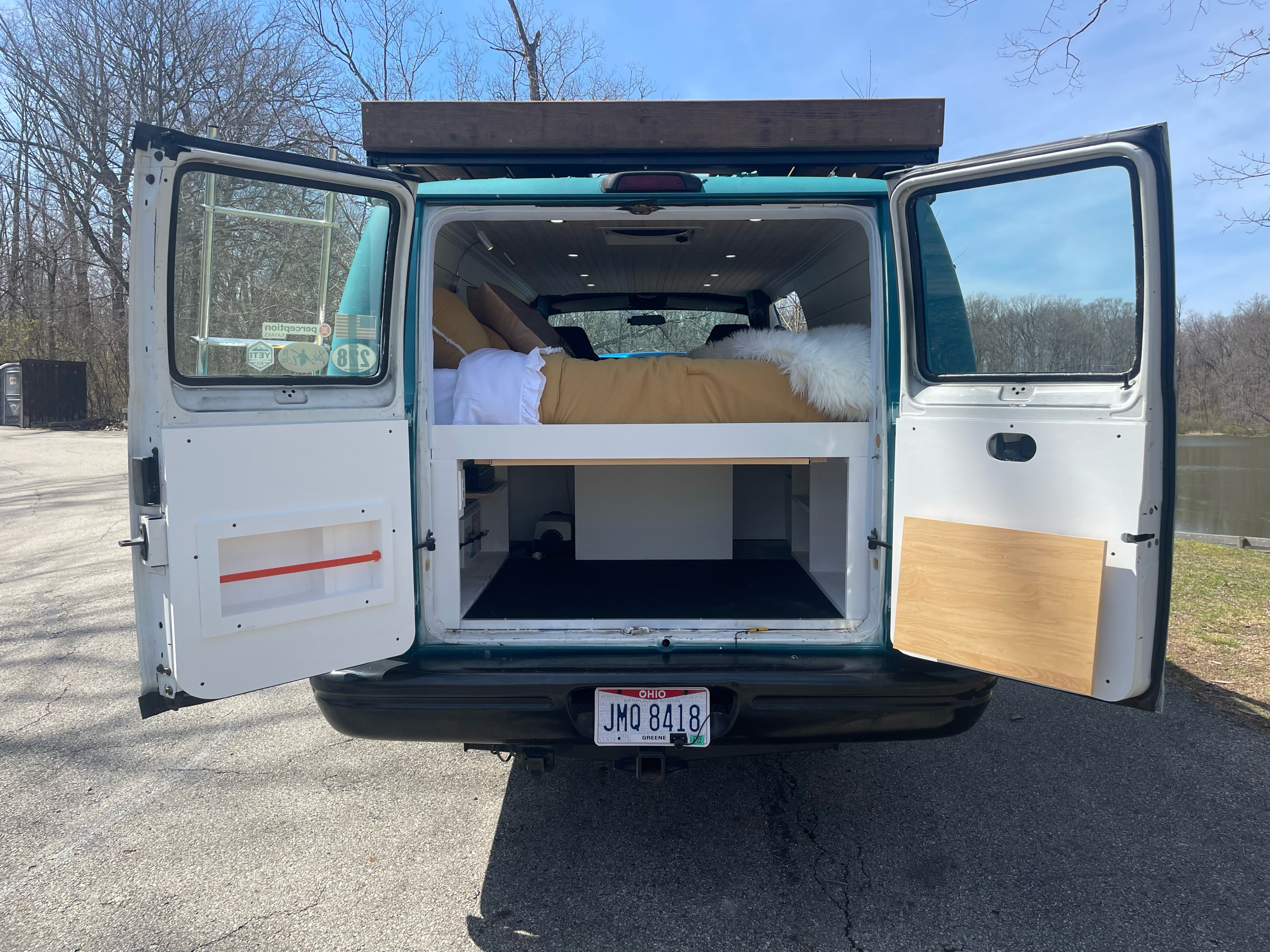 Converted camper van showing interior bed and storage from the rear. Ideal for your next RV rental adventure.. Dodge Ram 3500 2003