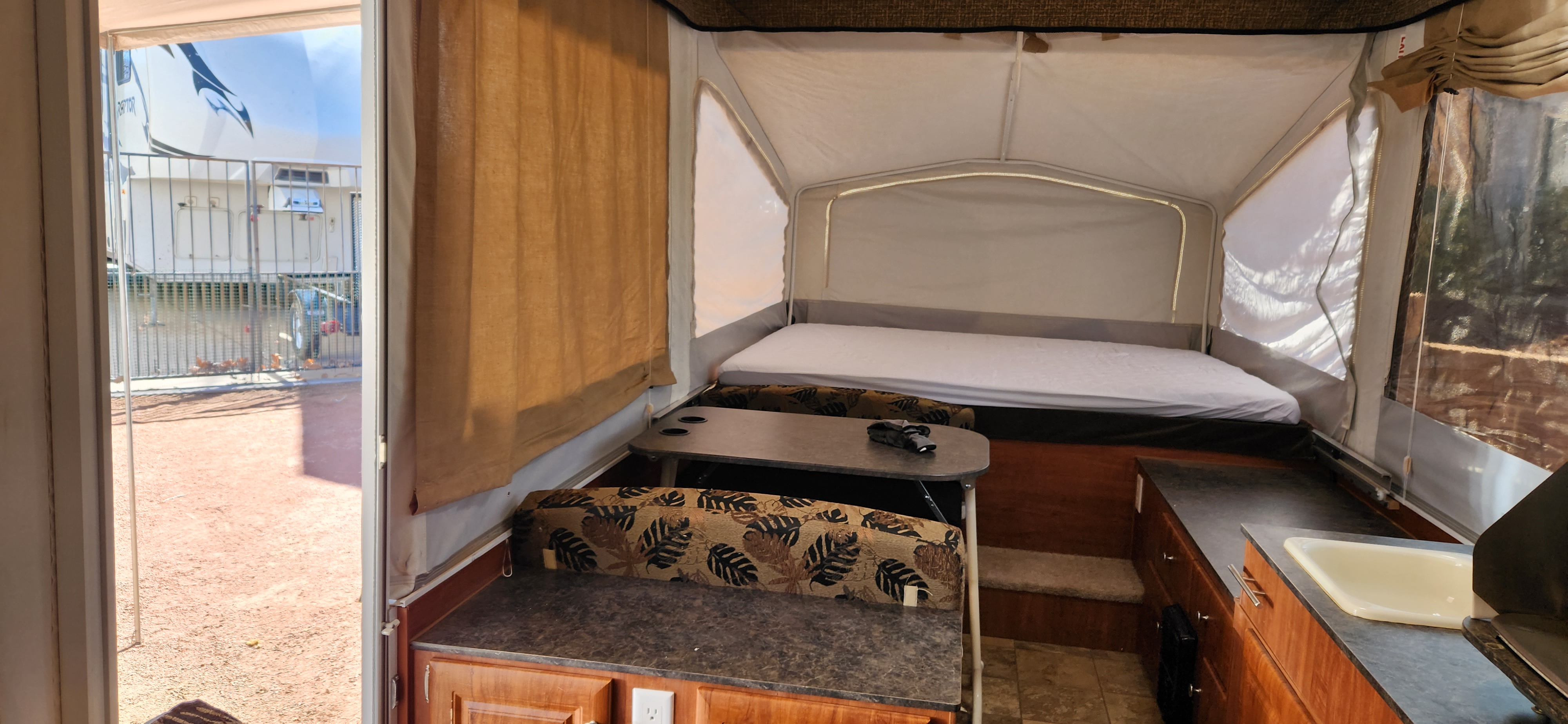 Pop-up RV rental interior: A comfortable bed, dinette, and kitchen counter with sink.. Jayco Jay 2012